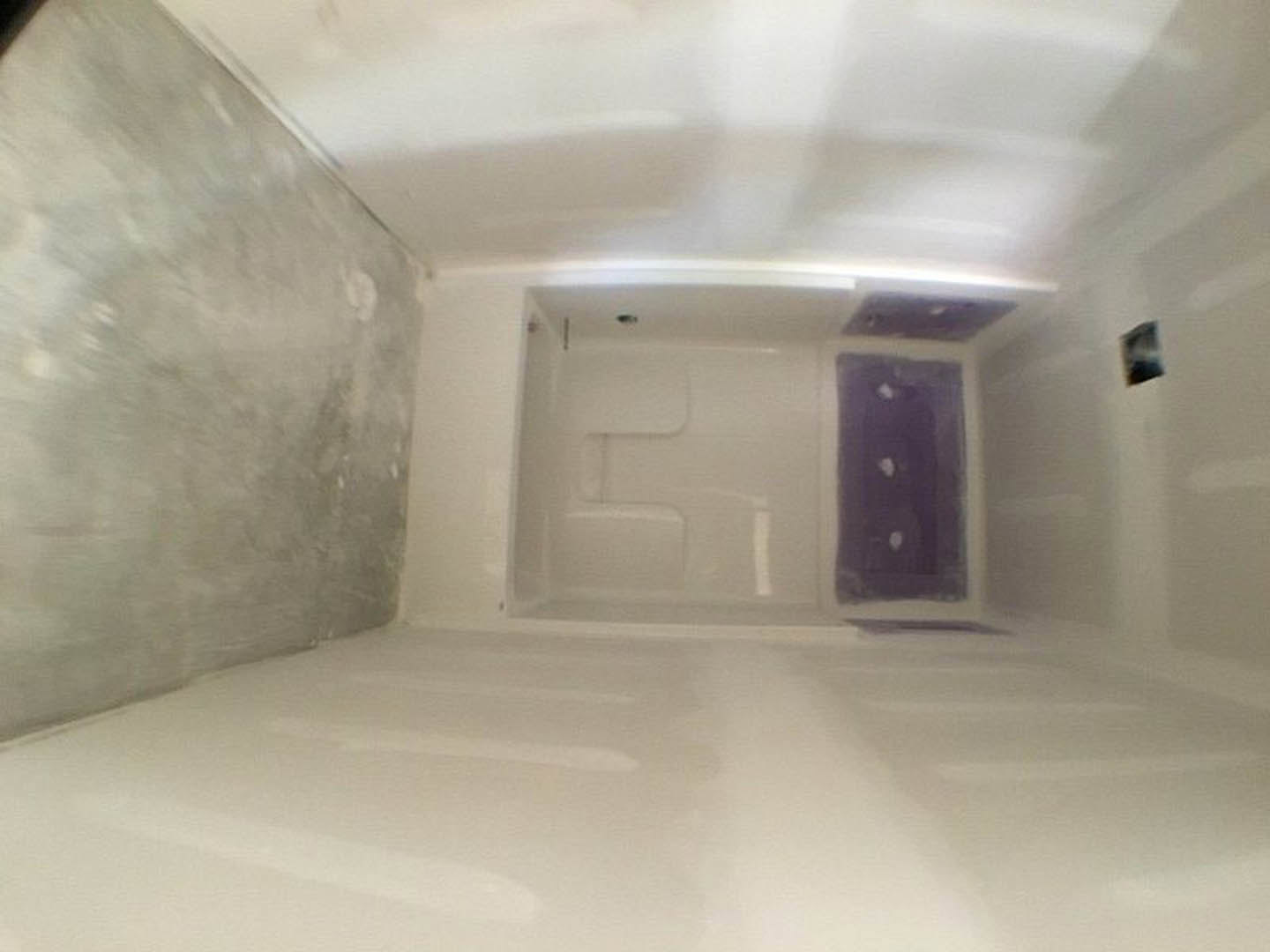 Bathroom with white walls, glass shower enclosure, and purple sink on white vanity