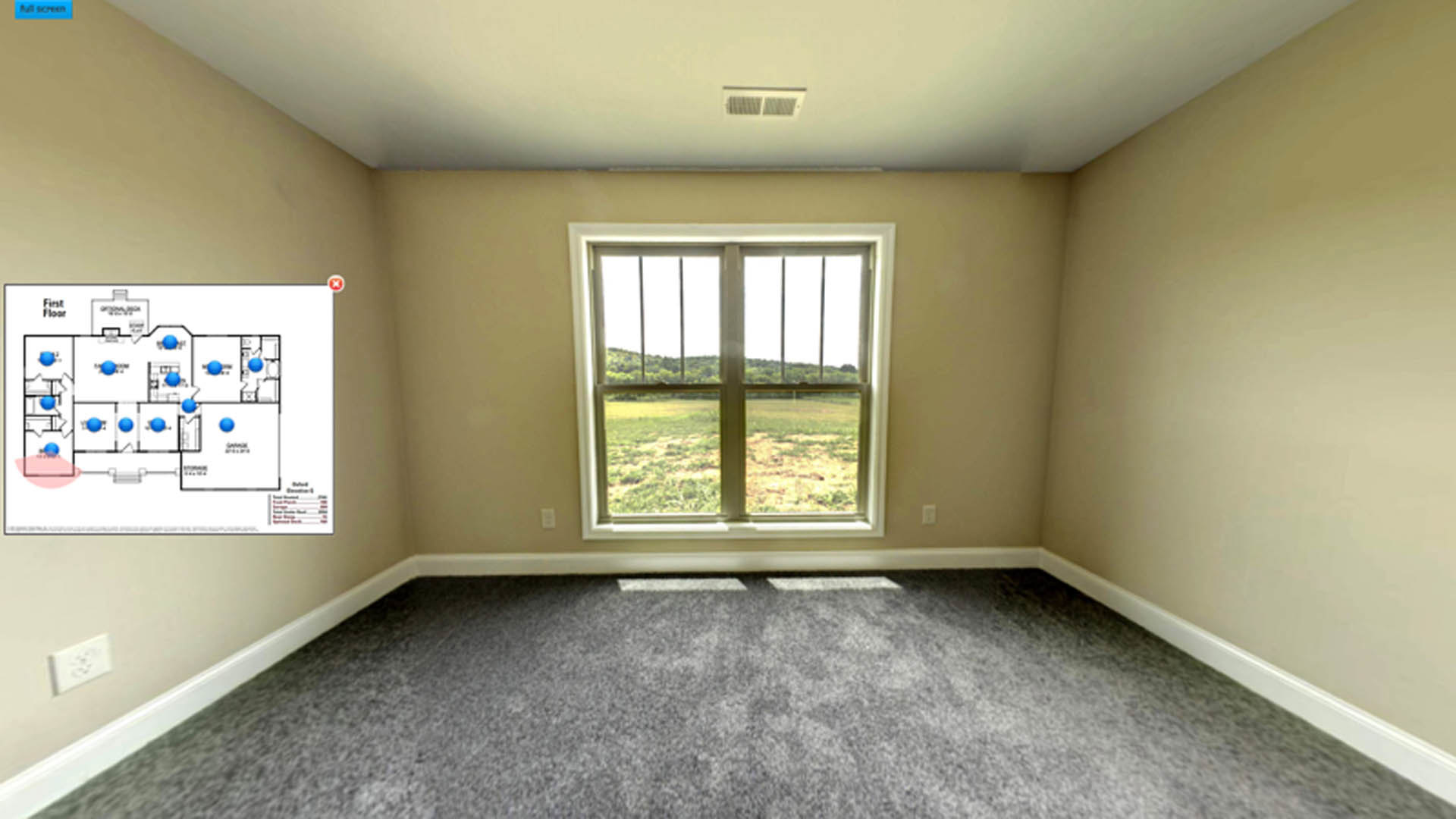 Bright room with white plaster walls, large window overlooking grassy field, grey carpet flooring, and ceiling with recessed lighting.