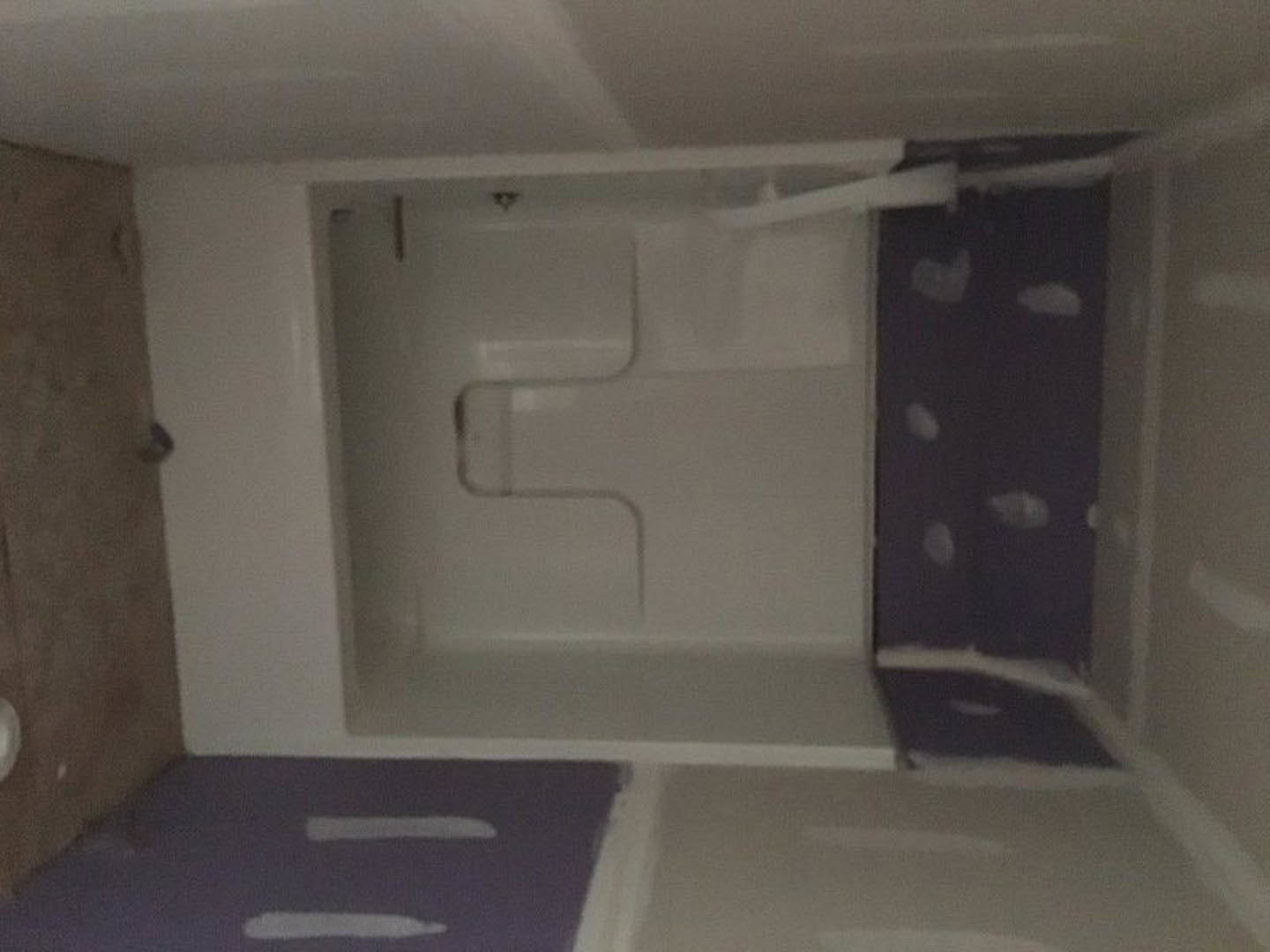 Glass-enclosed shower with white tile walls, chrome fixtures, and adjacent toilet in modern bathroom.