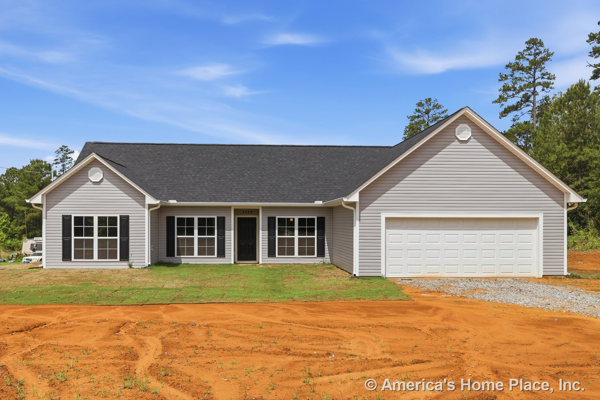 Gray vinyl siding exterior with black shingle roof, two-car garage door, large front windows with white trim, covered entry porch, and paved driveway.