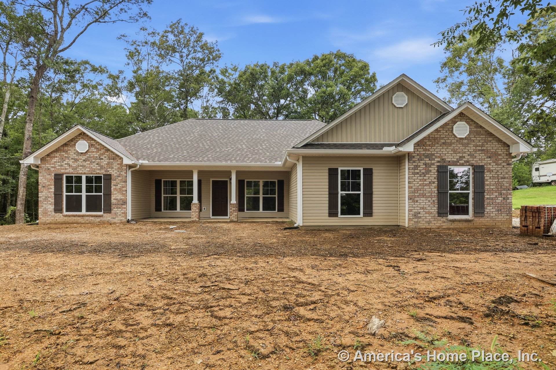 Brick and vinyl siding exterior with covered front porch supported by double columns, dark shutters framing multiple large windows, gable roof, and decorative trim surrounding the