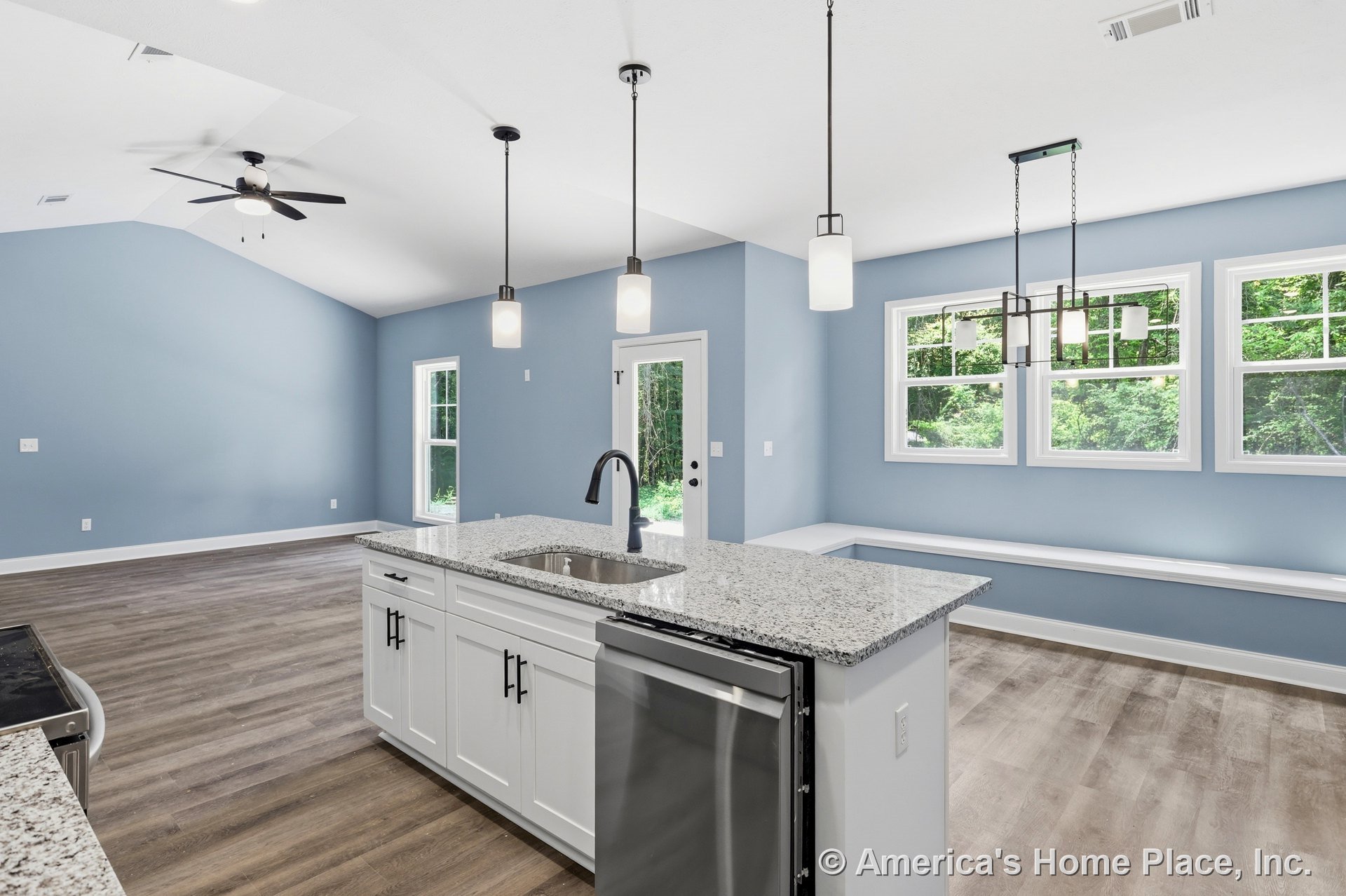 Granite kitchen island with white shaker cabinets, pendant lighting, wood-look flooring, built-in window bench, vaulted ceiling with ceiling fan, stainless steel dishwasher, open