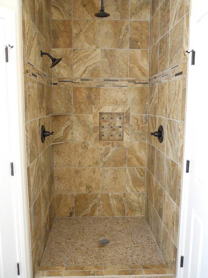 Walk-in shower with marble tile floor, wall-mounted shower head, recessed drain, and glass door