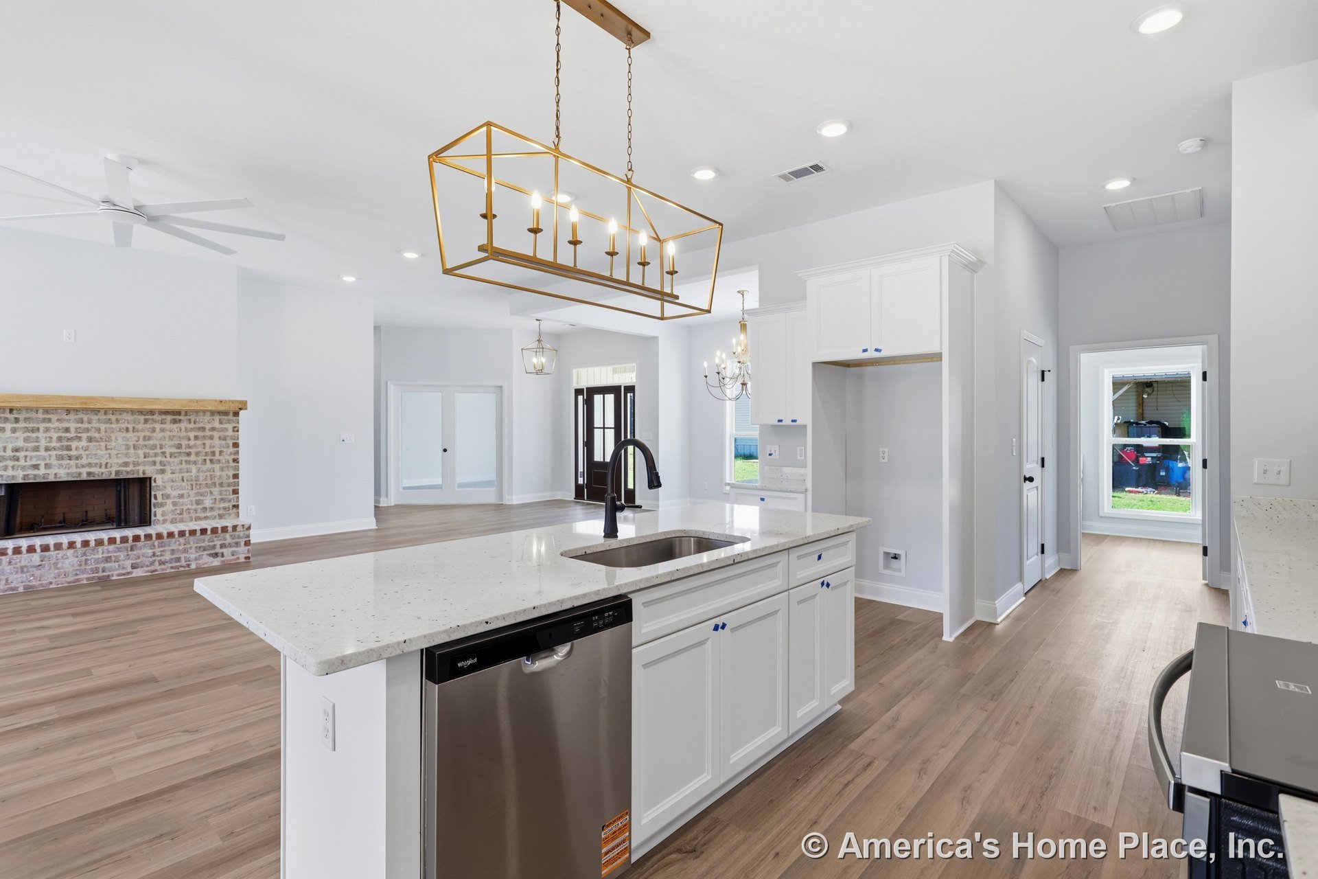 White cabinetry kitchen with stainless steel dishwasher, undermount sink set in quartz countertop, pendant light hanging from ceiling, window overlooking garage, hardwood flooring