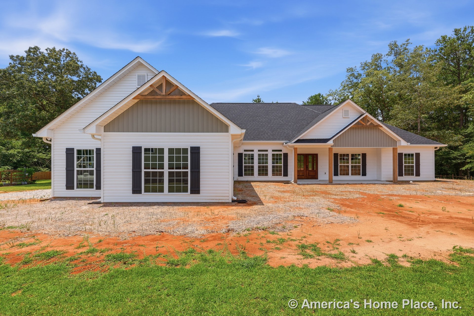 White horizontal siding exterior with large front windows, black shutters, black roof shingles, covered porch entry supported by wooden columns, decorative gable trim, and paneled