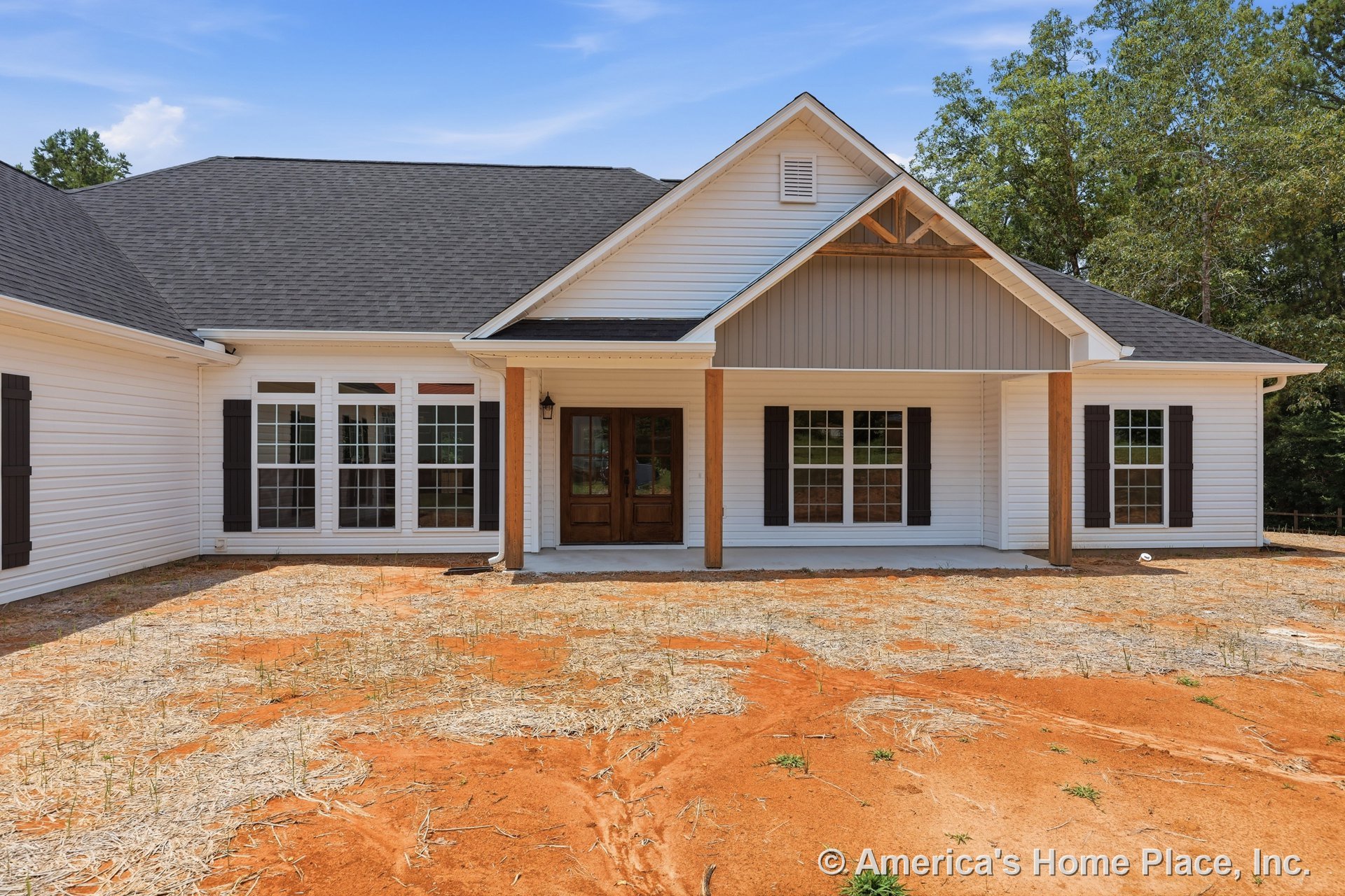 Covered front porch with wood columns, double entry doors, white siding exterior, dark roof shingles, large windows with shutters, and wood trim accents.