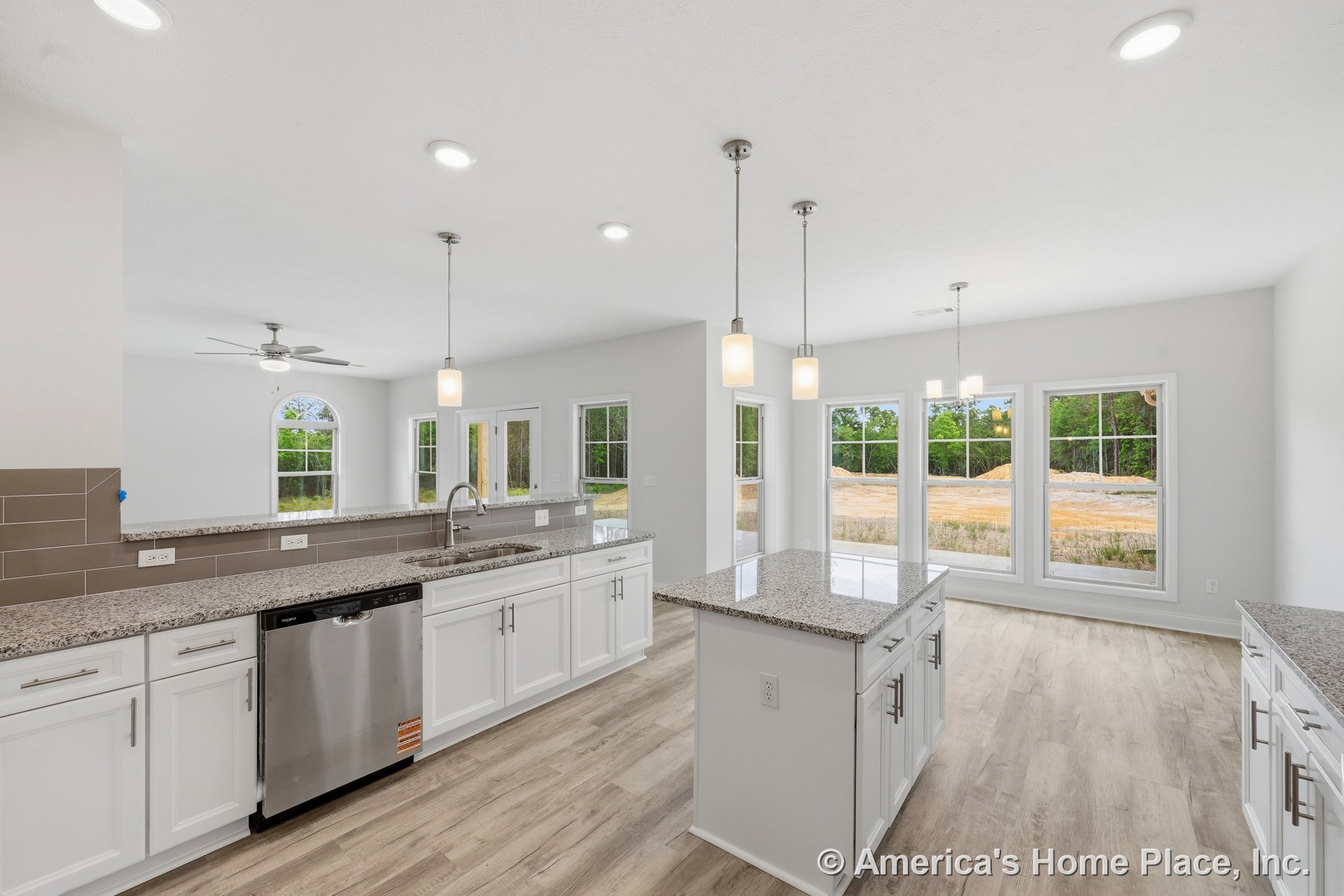 White shaker cabinets and granite countertops in a kitchen with pendant lights above the island, stainless steel dishwasher, tile backsplash, recessed lighting, and light wood