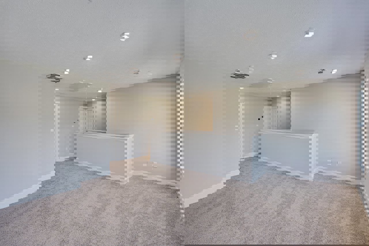 Reception area with carpeted floor, white walls and trim, square-paneled white door, recessed ceiling lights, and a white ceiling