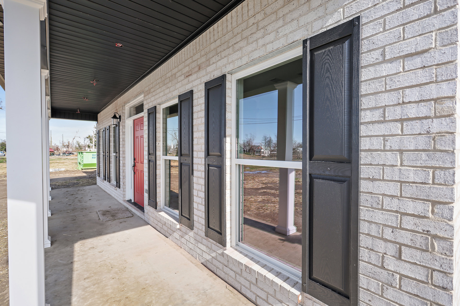 Red brick exterior with white-trimmed windows and a red front door