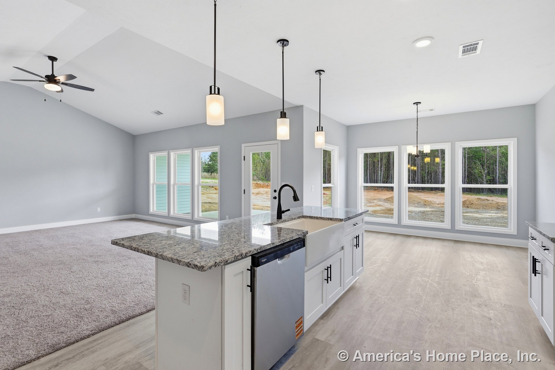 Spacious kitchen with central island featuring built-in sink and dishwasher, white cabinetry, stainless steel refrigerator, ceiling fan with light, recessed lighting, and open
