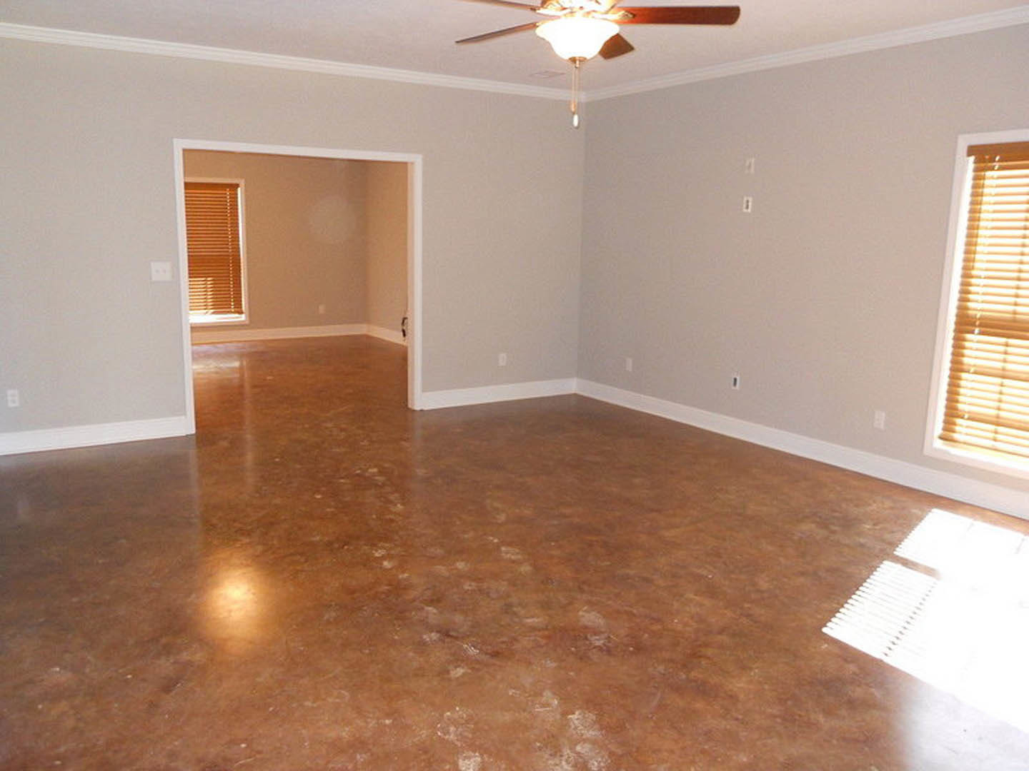 White walls and wood laminate flooring in a room with a ceiling fan, window with blinds, and recessed lighting.