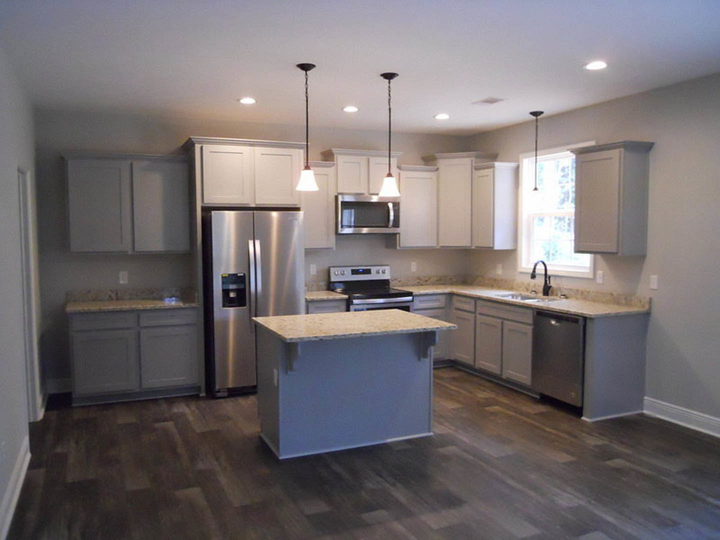 Kitchen with stainless steel refrigerator, stainless steel appliances, white countertop, tile floor, and white cabinetry