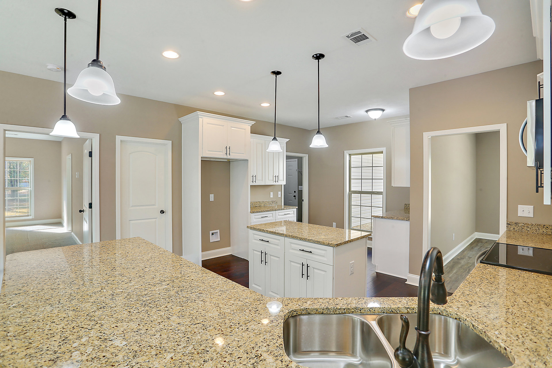 Granite countertops, white shaker cabinets, stainless steel sink, tile backsplash, recessed lighting, smoke detector on ceiling