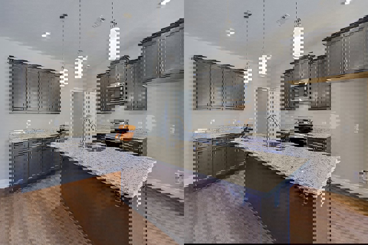 Granite countertops and kitchen island, stainless steel sink, tile backsplash, white cabinetry, built-in microwave, recessed lighting