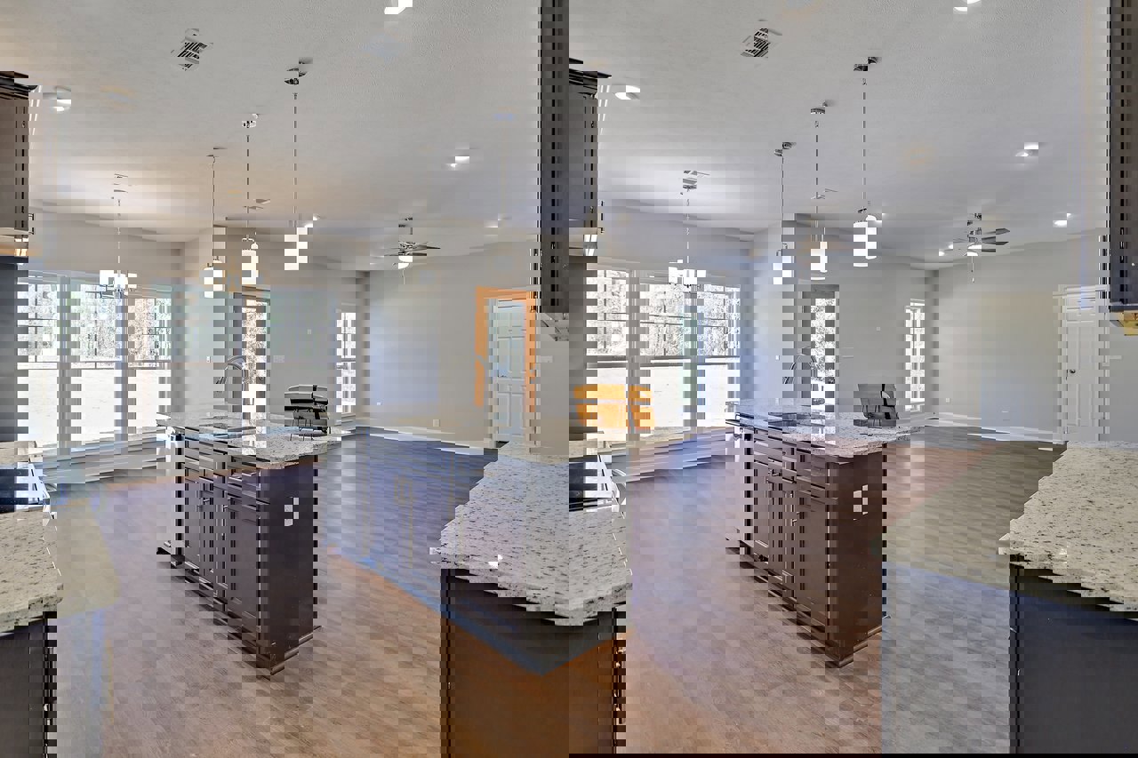 Kitchen with wood flooring, ceiling fan, white cabinetry, granite island countertop, stainless steel appliances, and large windows providing natural light