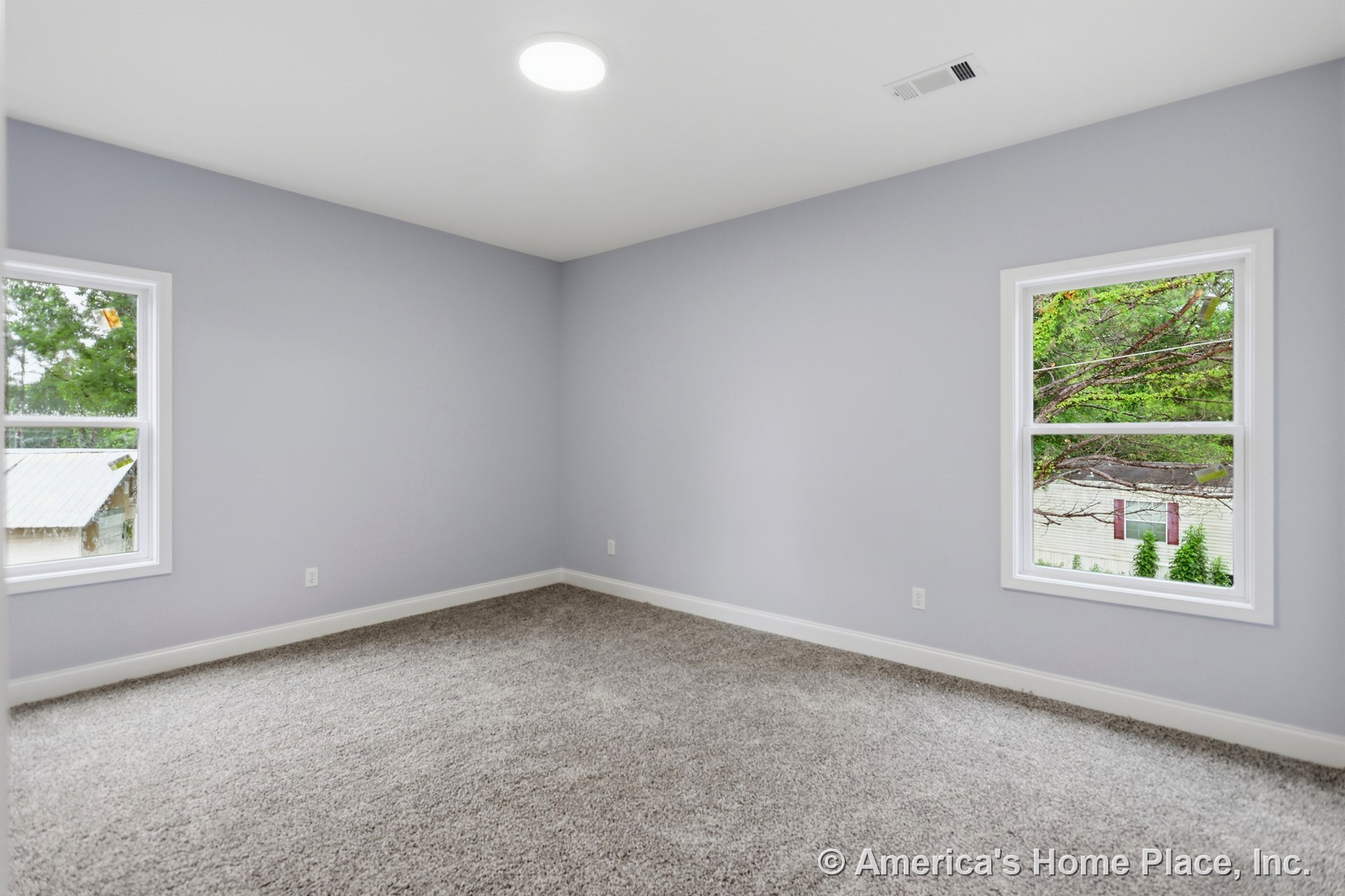 Bedroom with light gray walls, white trim and baseboards, two double-hung windows, neutral plush carpet flooring, recessed ceiling light, and ceiling vent.