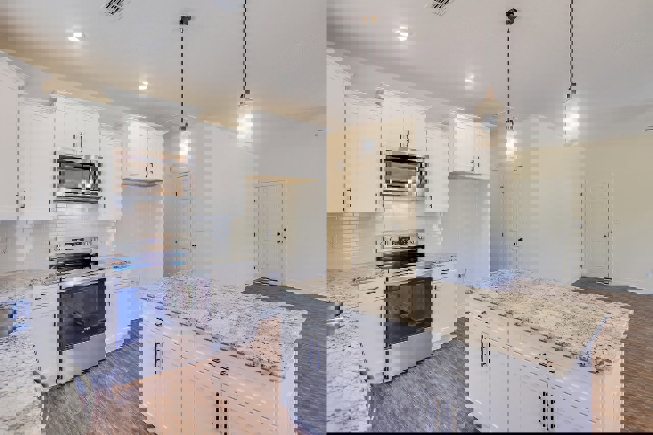 White kitchen cabinets with granite countertops, stainless steel oven with glass door and interior lights, white door with black knobs, bowl on countertop, light-colored flooring