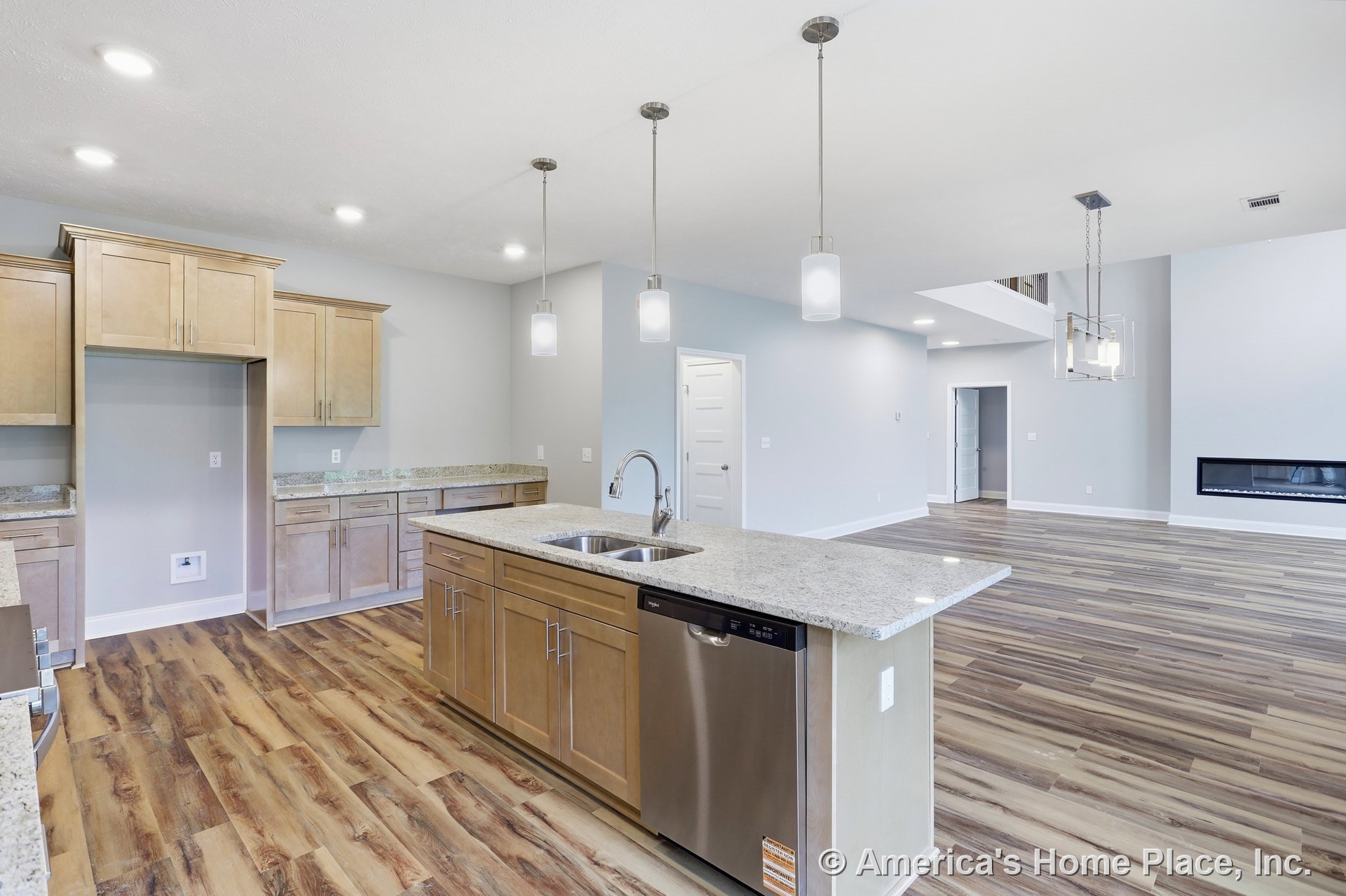 Light wood kitchen cabinets and granite countertops with pendant lights above the island, wood-look flooring throughout, stainless dishwasher and island sink, open concept layout