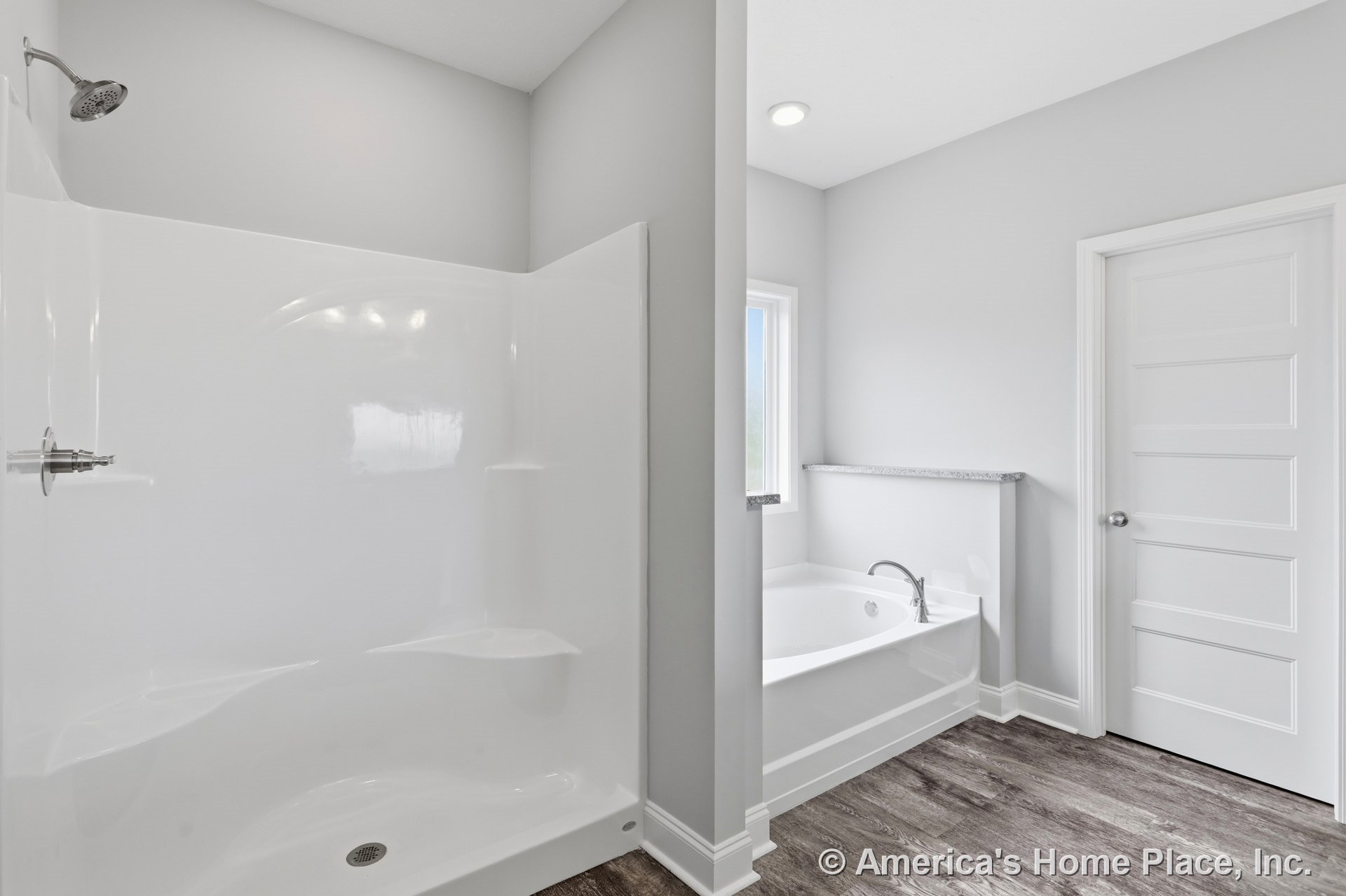 Walk-in shower enclosure and separate soaking bathtub beneath a trimmed window, recessed ceiling light, wood-look flooring, paneled interior door, modern finishes, white walls