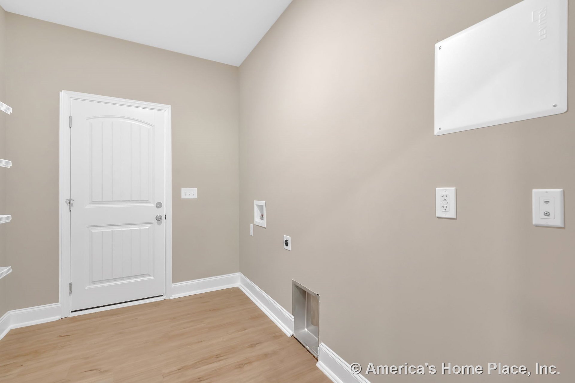 Laundry room with washer and dryer hookups, light wood flooring, beige walls, white baseboards, white paneled door, wall-mounted utility panel, built-in shelving, electrical