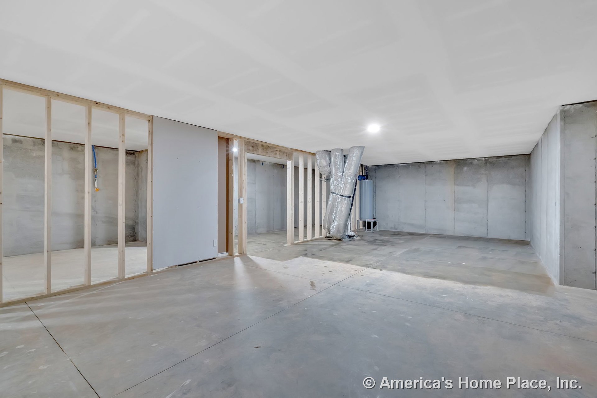 Unfinished basement with concrete floors, bare concrete walls, exposed wood framing, visible ductwork, utility area housing a water heater, and unfinished drywall ceiling; no