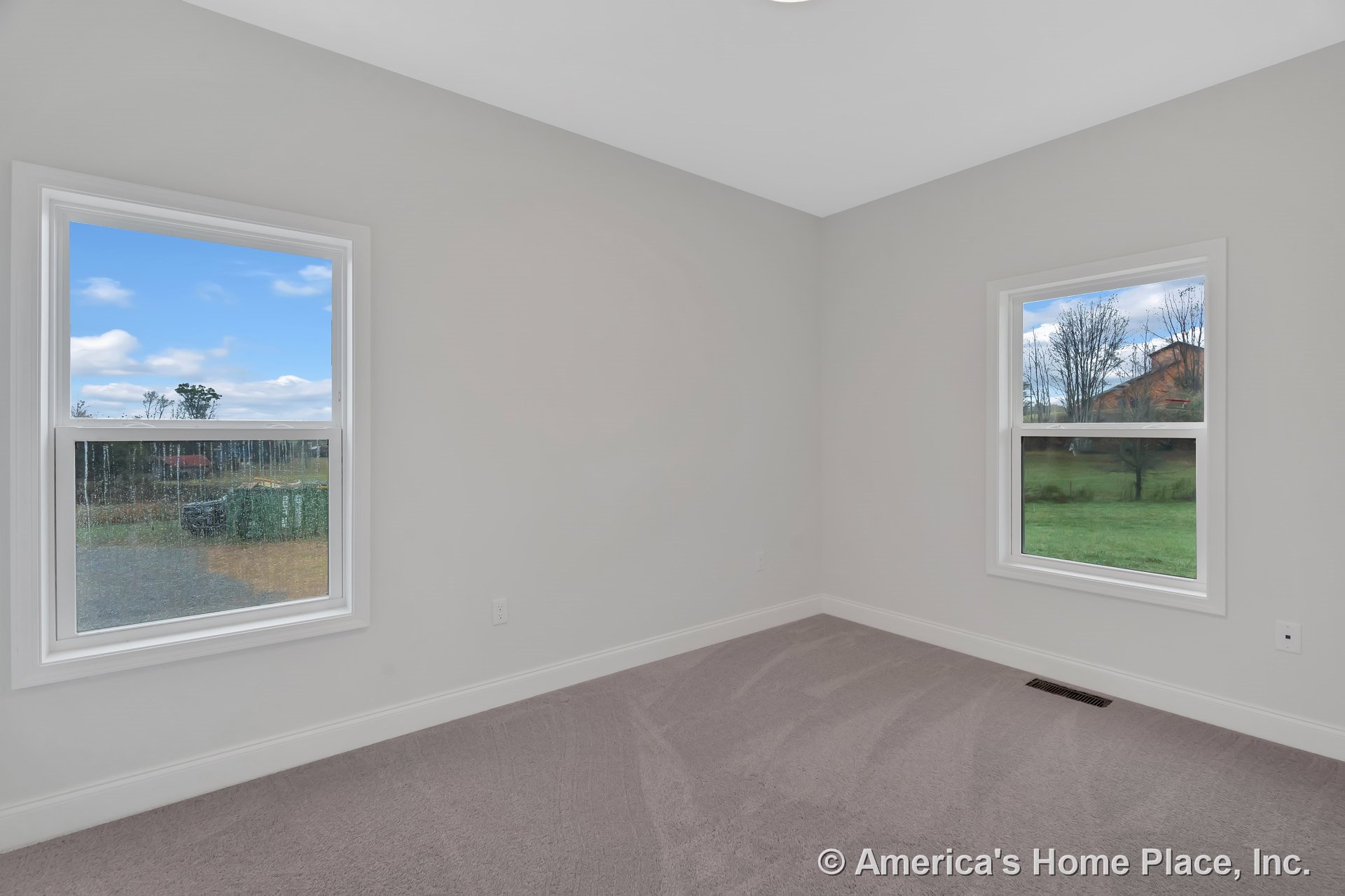 Bedroom with two large double-hung windows, light gray carpet flooring, white baseboards, neutral wall paint, ceiling light fixture, and rectangular room layout.