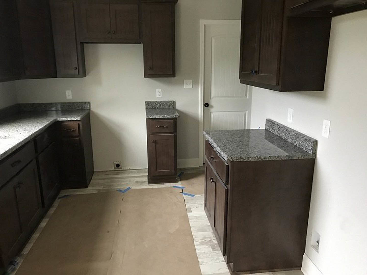 Kitchen with dark wood cabinets, granite countertops, stainless steel appliances, and tile flooring