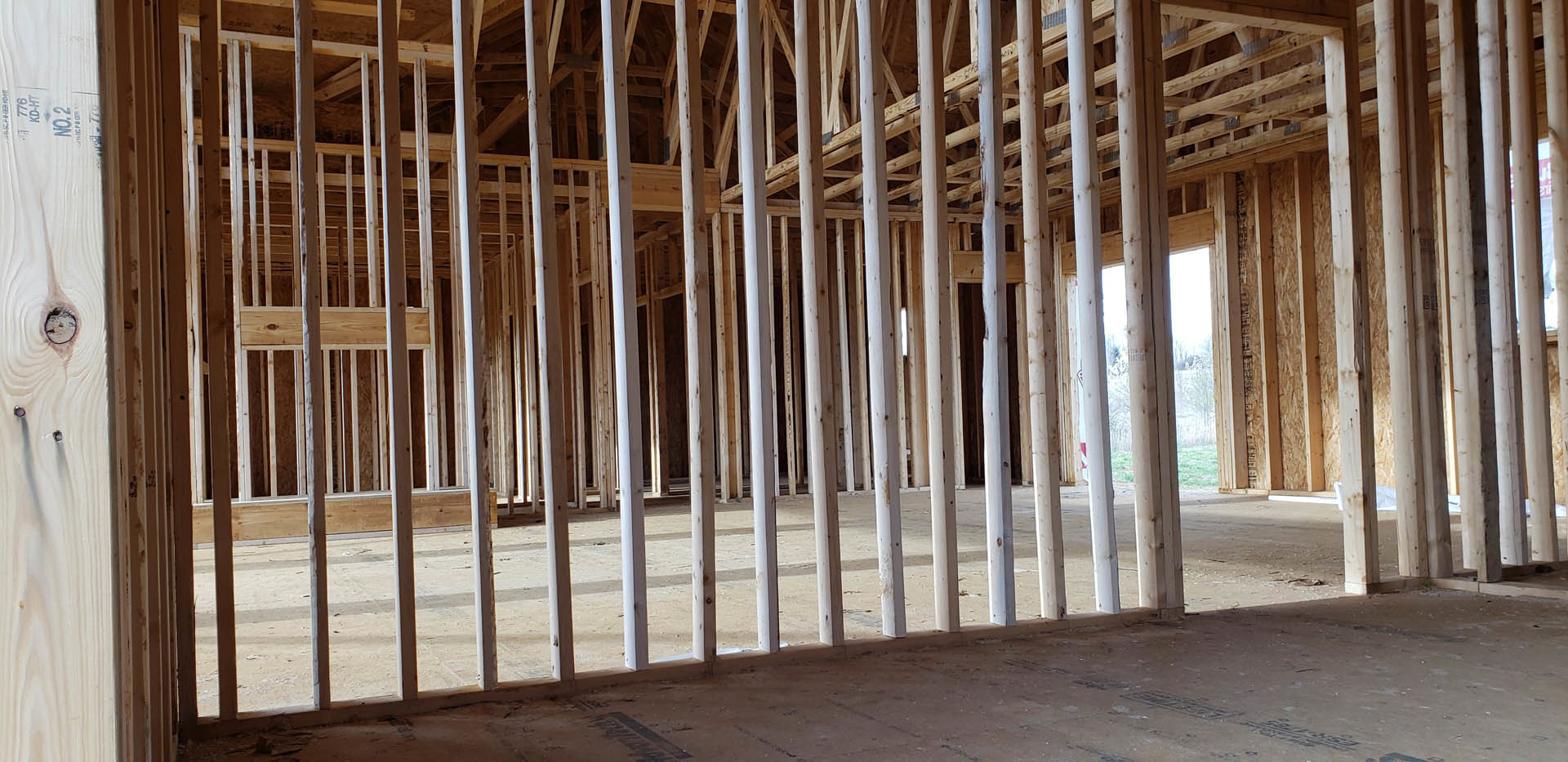 Exposed wooden framing with beams and planks forming the structure of a residential home under construction