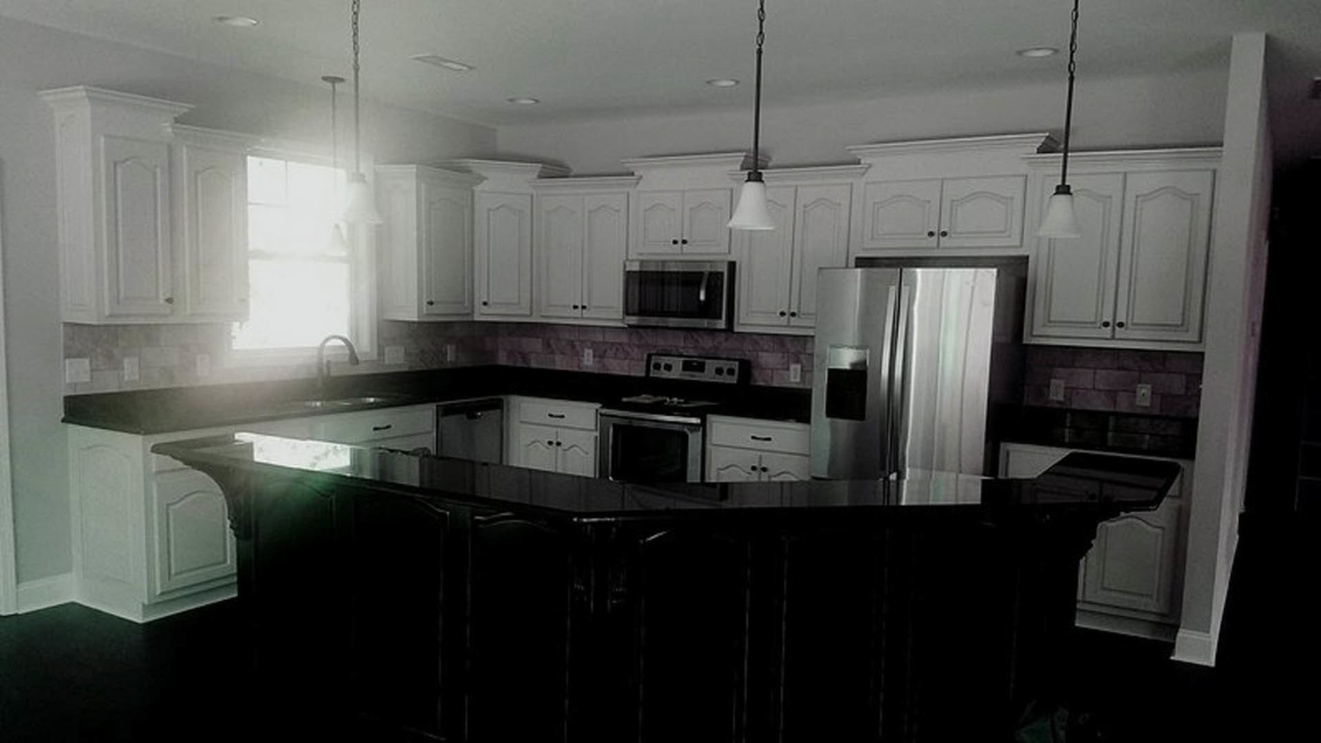 White kitchen cabinets, stainless steel refrigerator, stove and oven, black dining table, window with dark view, light countertops, modern appliances