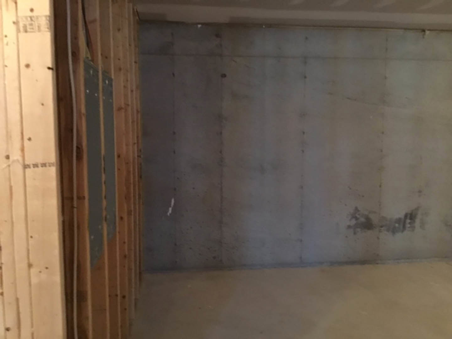 Concrete wall with wood framing, white floor, and plaster finishes in a modern indoor room