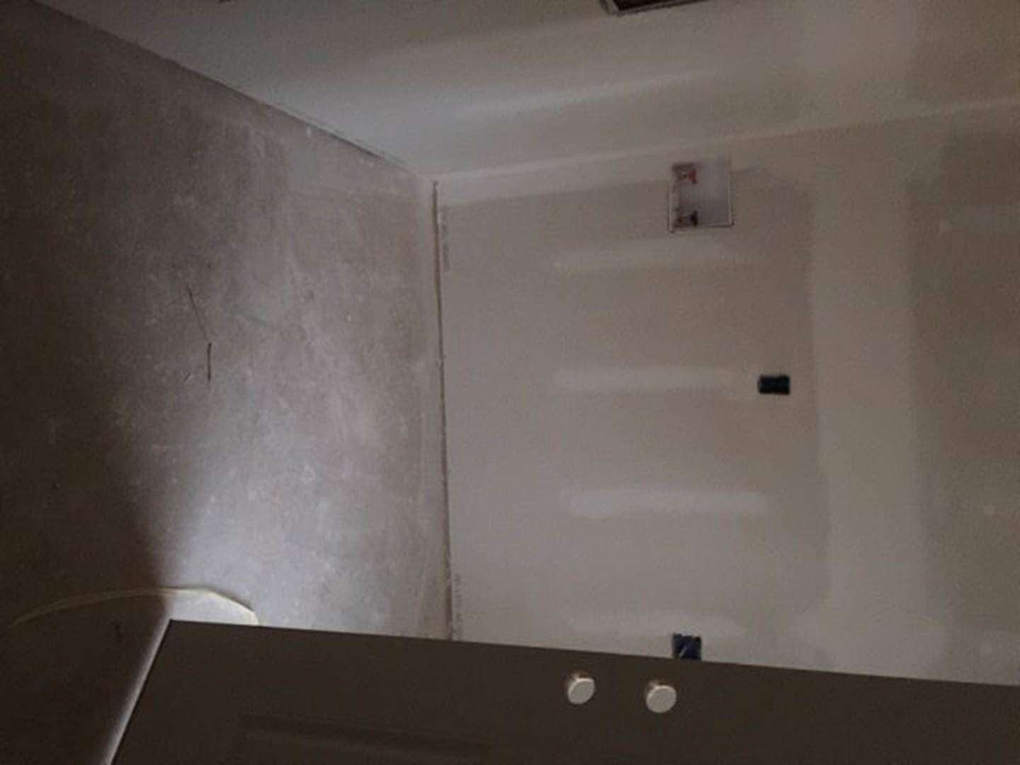 Bathroom with plaster walls, walk-in shower, white ceiling, and wooden door