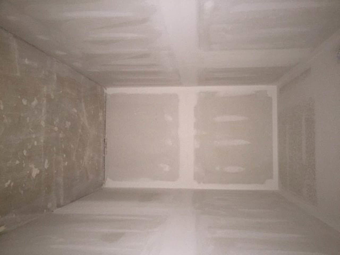 White-walled room with white plaster ceiling and light-colored floor