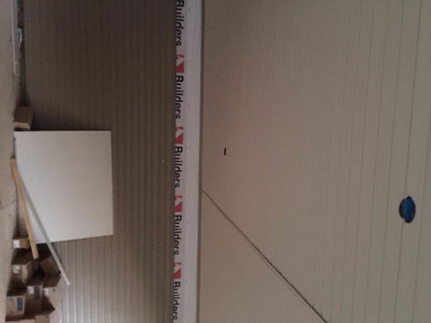 White wall with mounted whiteboard and blue marker tray