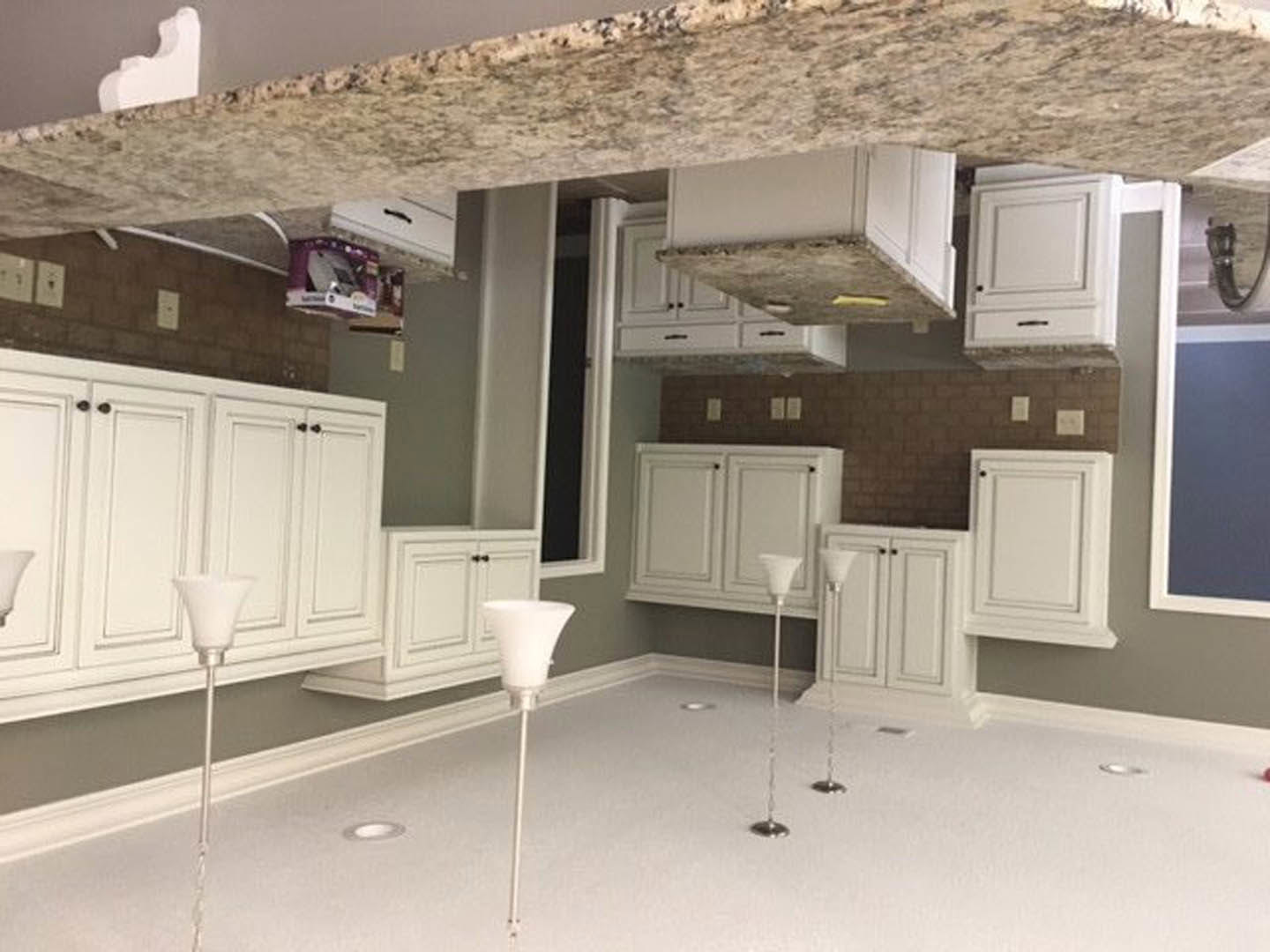White kitchen with shaker cabinets, marble countertops, stainless steel sink, and tile backsplash