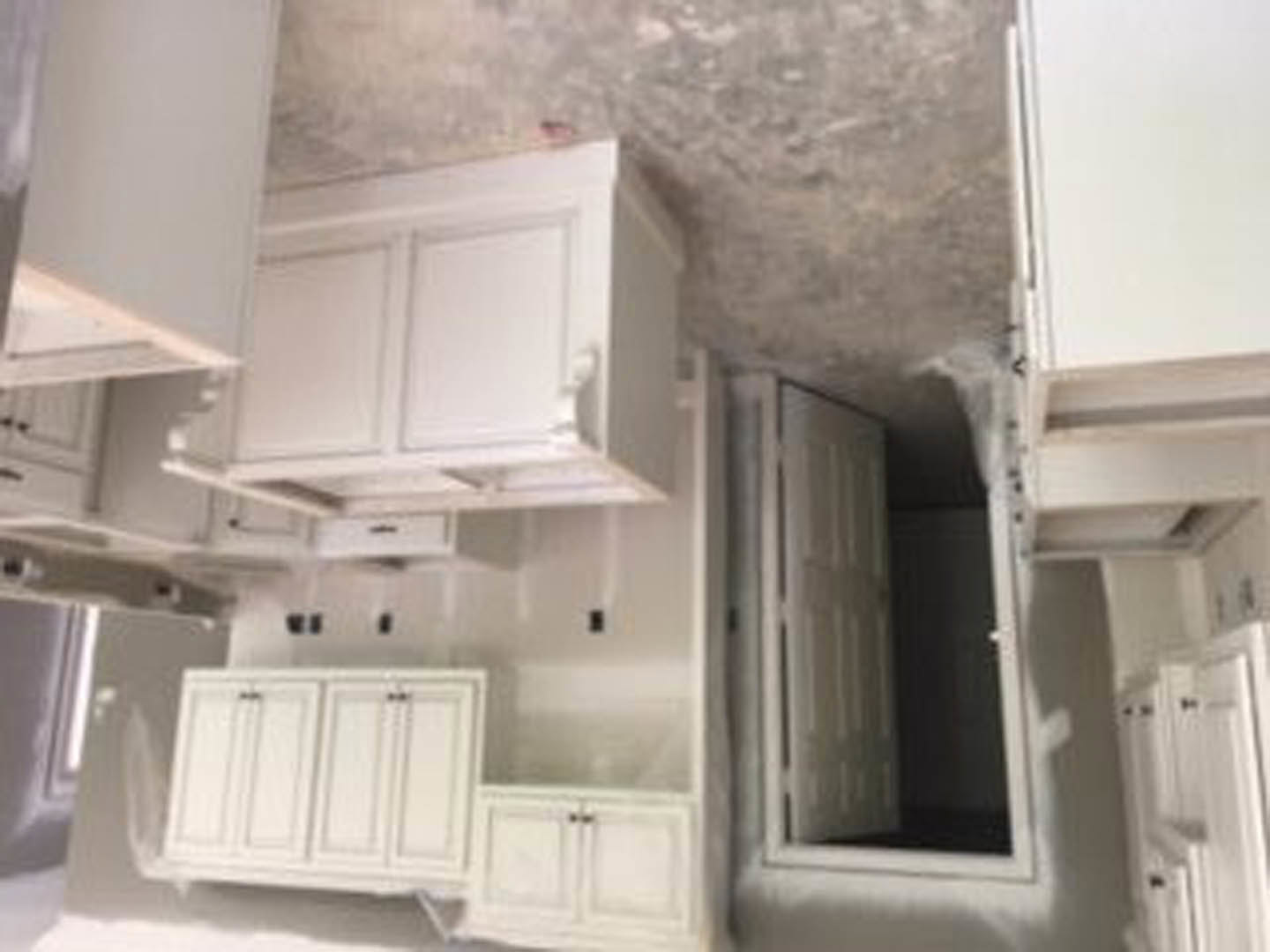 White shaker cabinets, stainless steel appliances, quartz countertops, undermount sink, tile backsplash, and recessed lighting in a modern kitchen.