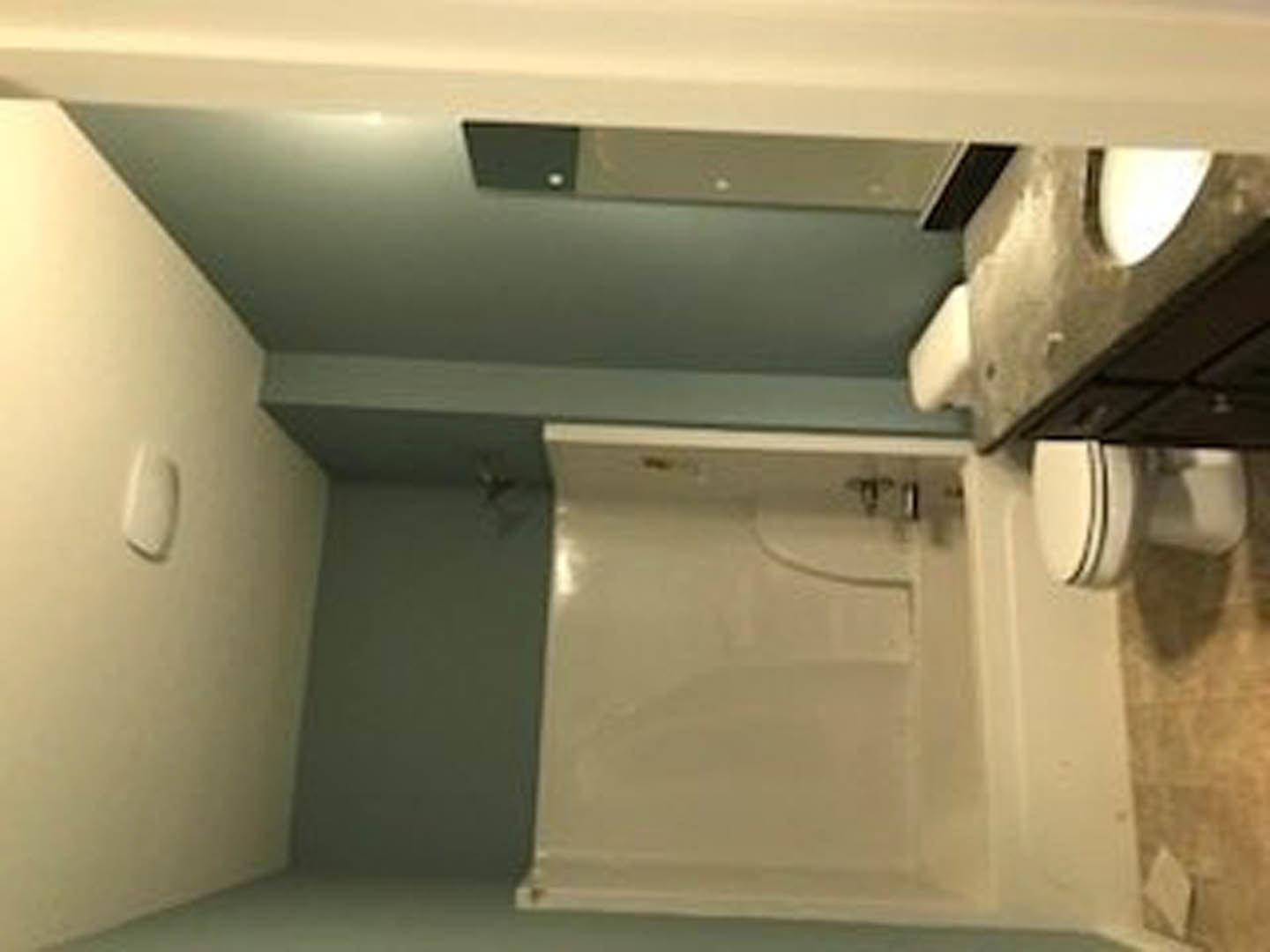 Modern bathroom featuring a white porcelain sink, matching toilet, glass-enclosed shower, and neutral tile walls