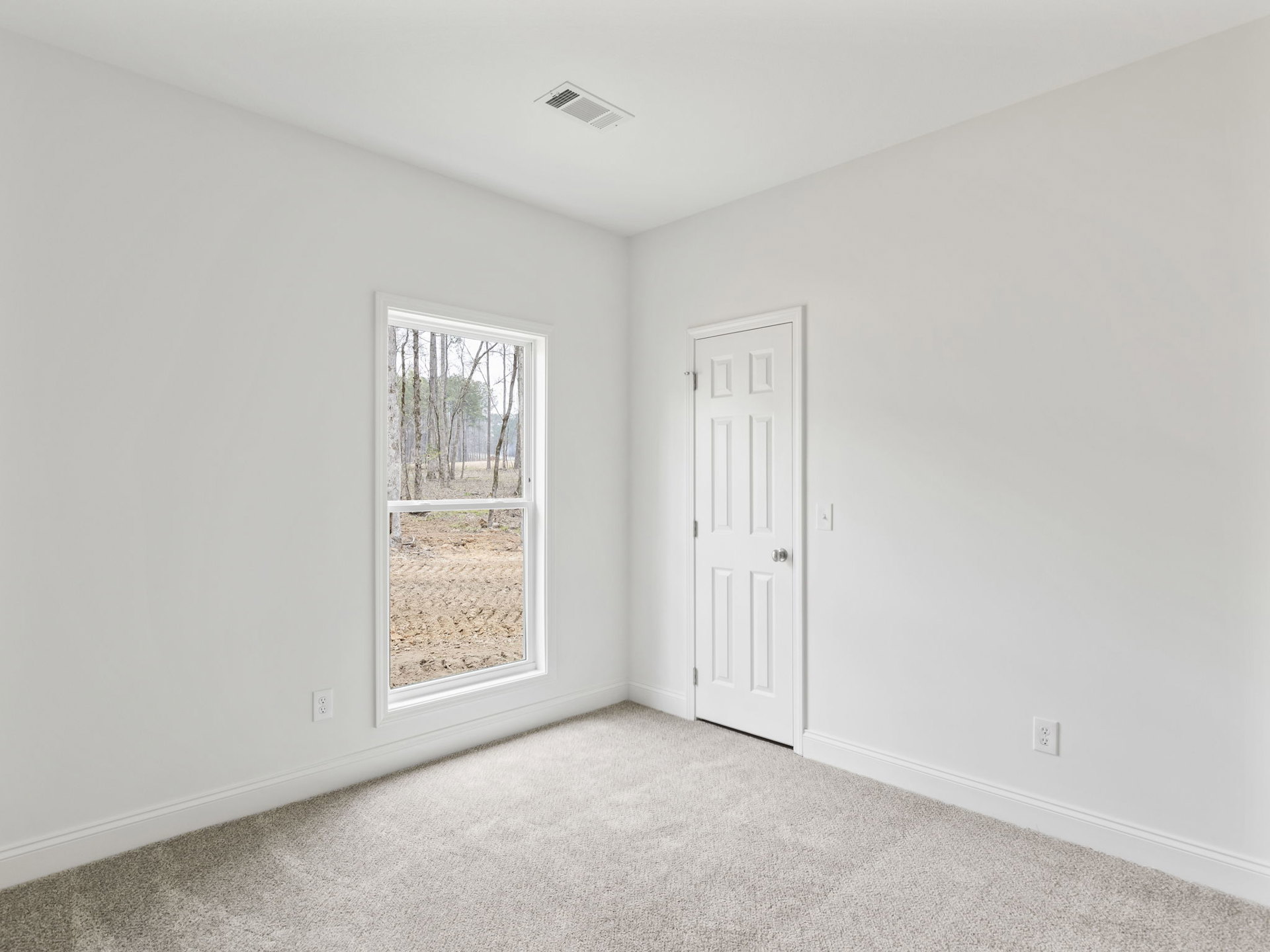 White carpeted bedroom with white door featuring silver knob, window overlooking trees, ceiling vent, and plaster walls with molding.