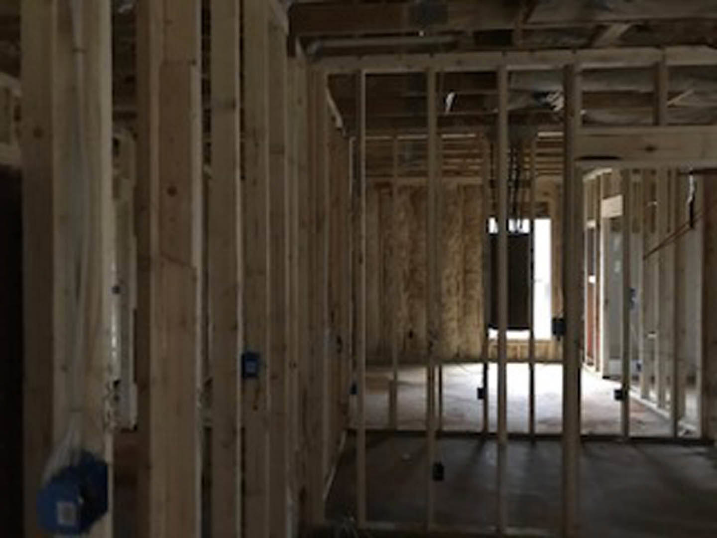 Room with exposed wood beams, unfinished walls, and visible ceiling insulation
