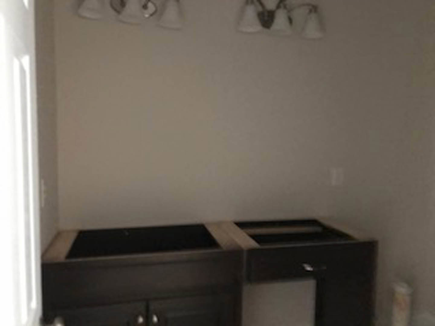 Black countertop with white stripe, surrounded by light cabinetry and drawers in a modern indoor room.