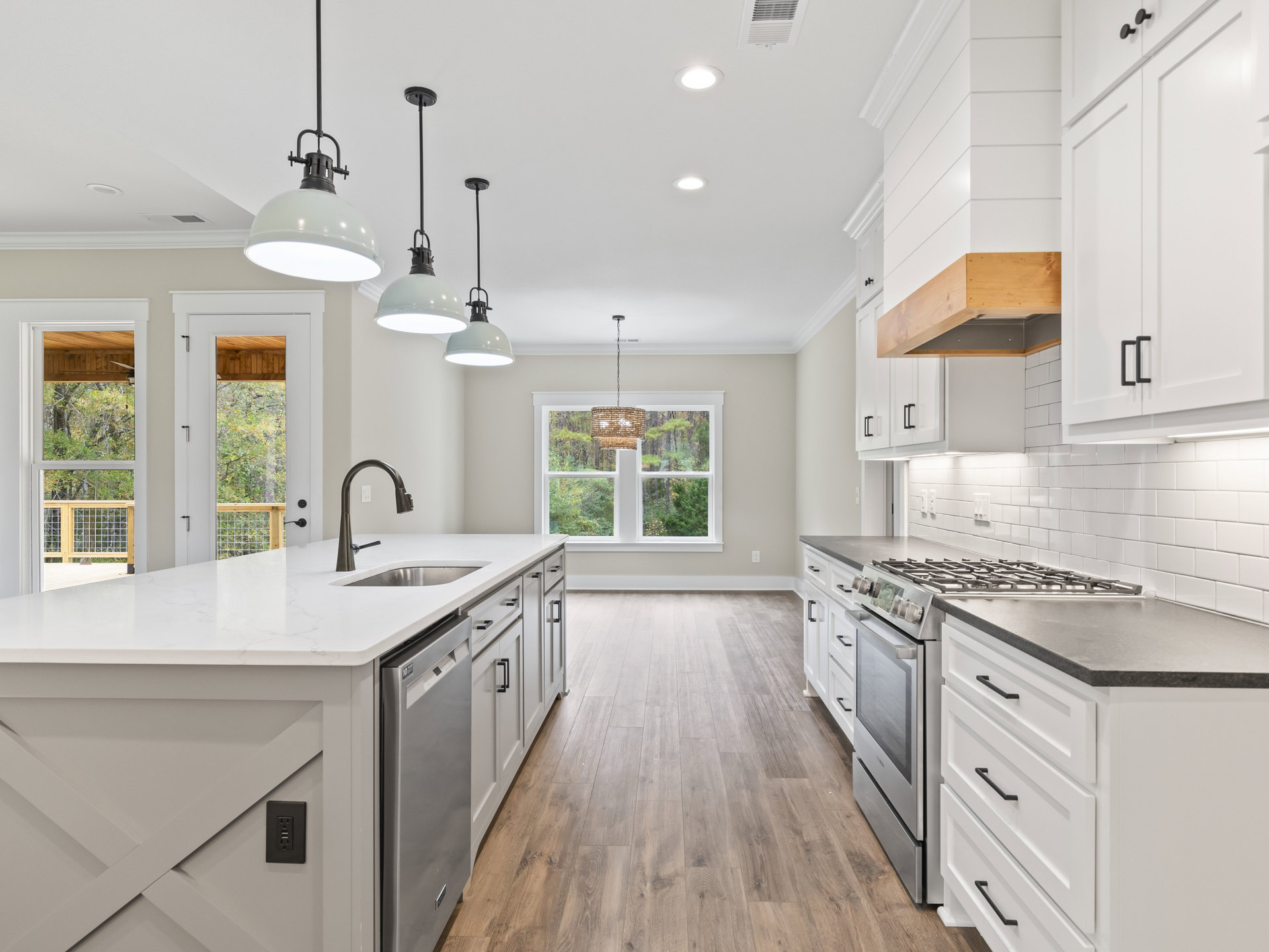 White kitchen with shaker cabinets, matching white appliances, woven pendant light, black electrical outlet, stainless faucet on quartz countertop, refrigerator partially visible
