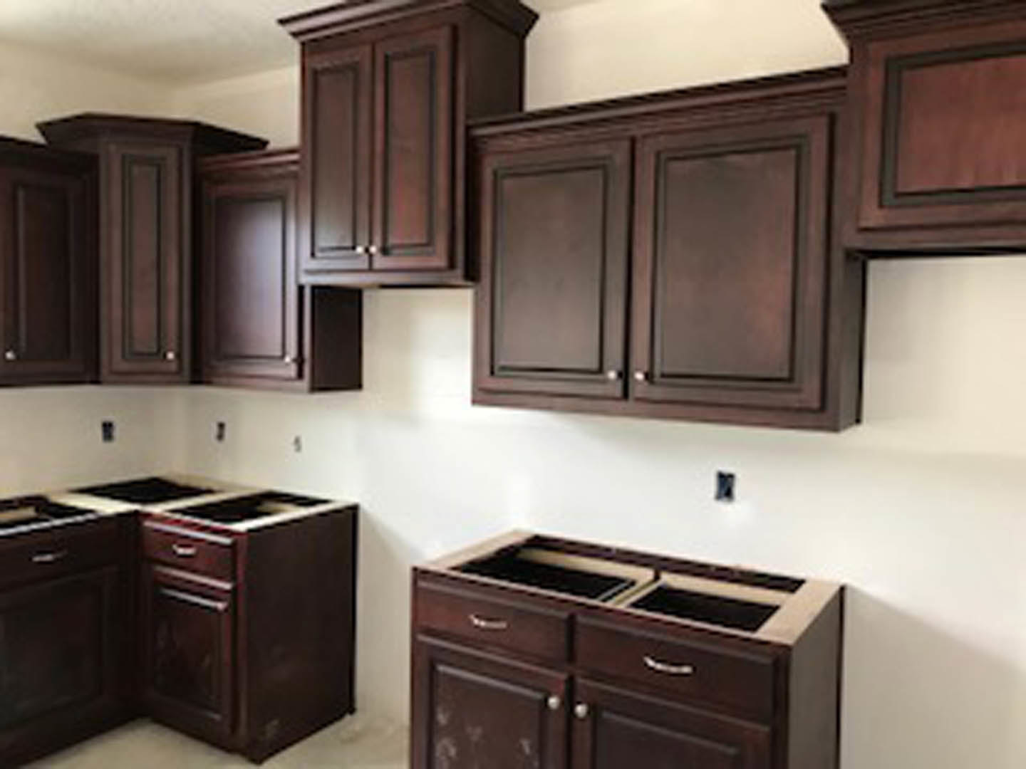Kitchen with dark wood cabinets, open upper cupboard, stainless steel appliances, and a window in the corner.