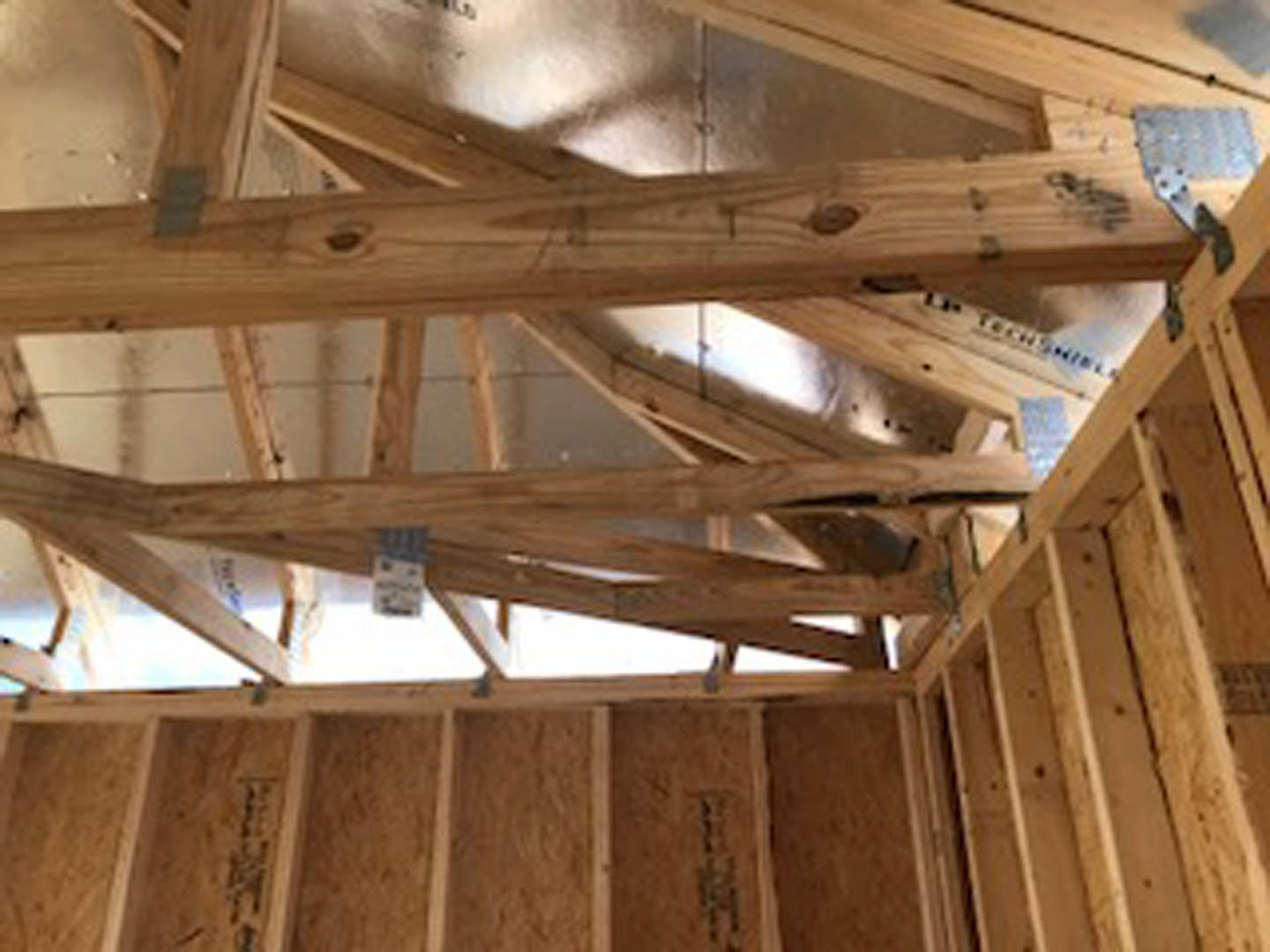 Exposed wooden beams and planks with building insulation in a residential interior under construction