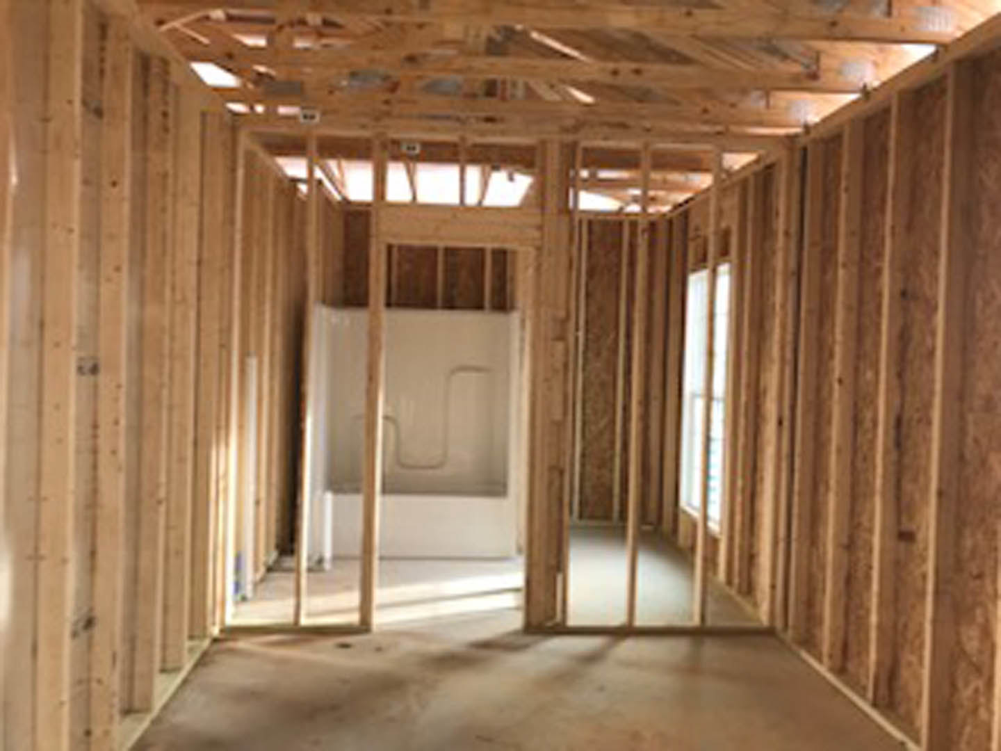 Curved glass shower door, wooden plank ceiling, white walls, window with frosted glass, indoor bathroom space
