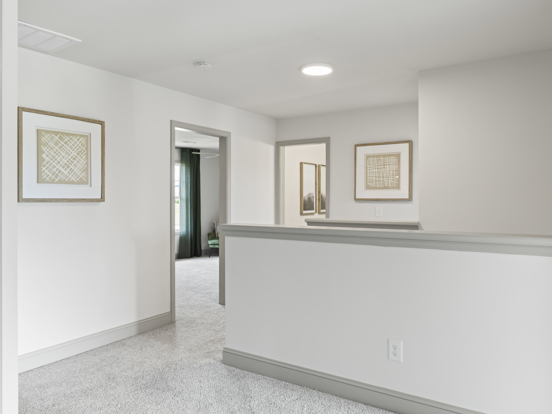 Hallway with white tile floor and white walls featuring gray trim, framed abstract art with white lines, ceiling-mounted light fixture