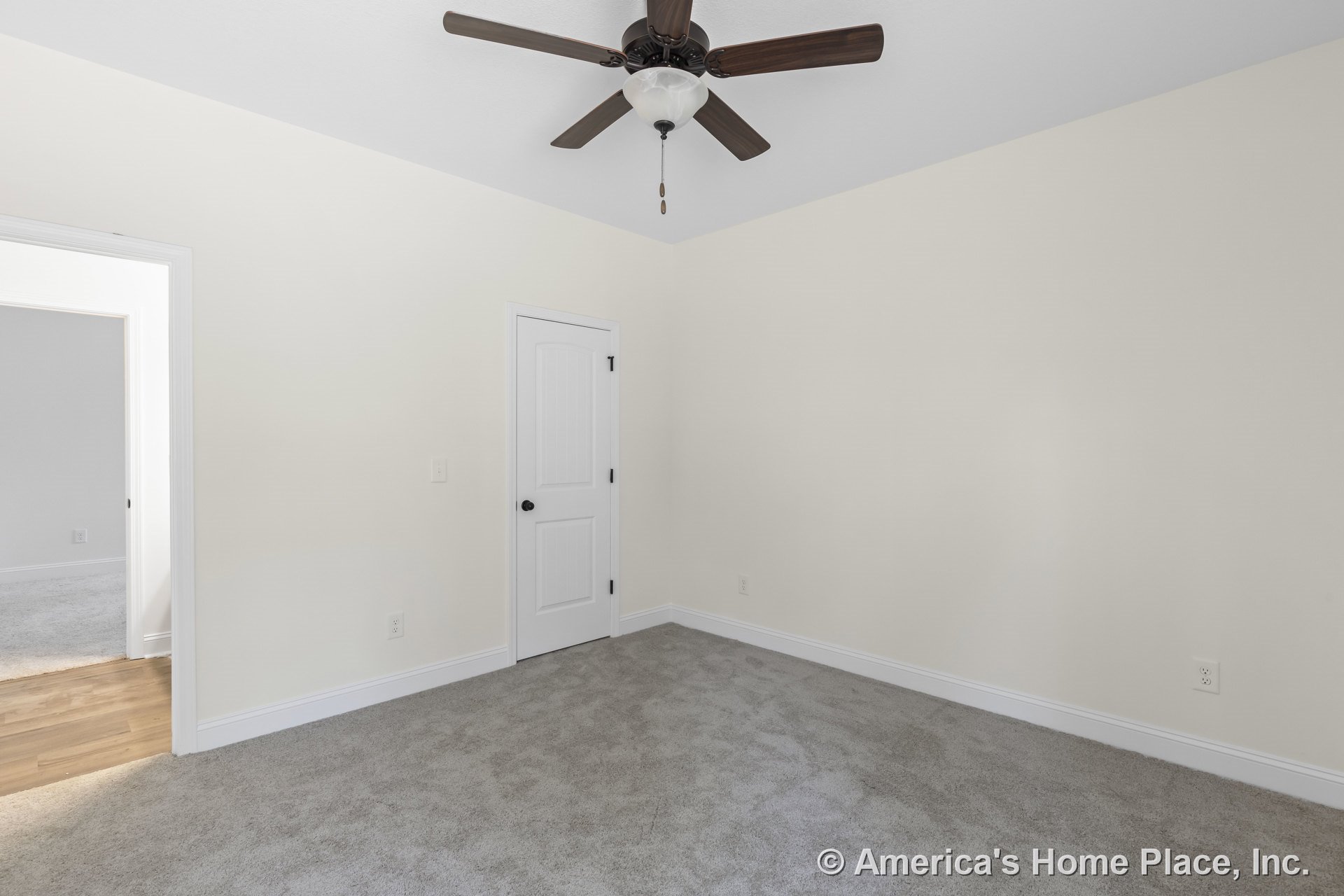 Bedroom with light carpet flooring, white baseboards and trim, ceiling fan with integrated light, paneled closet door, and neutral wall color; wood flooring visible at room