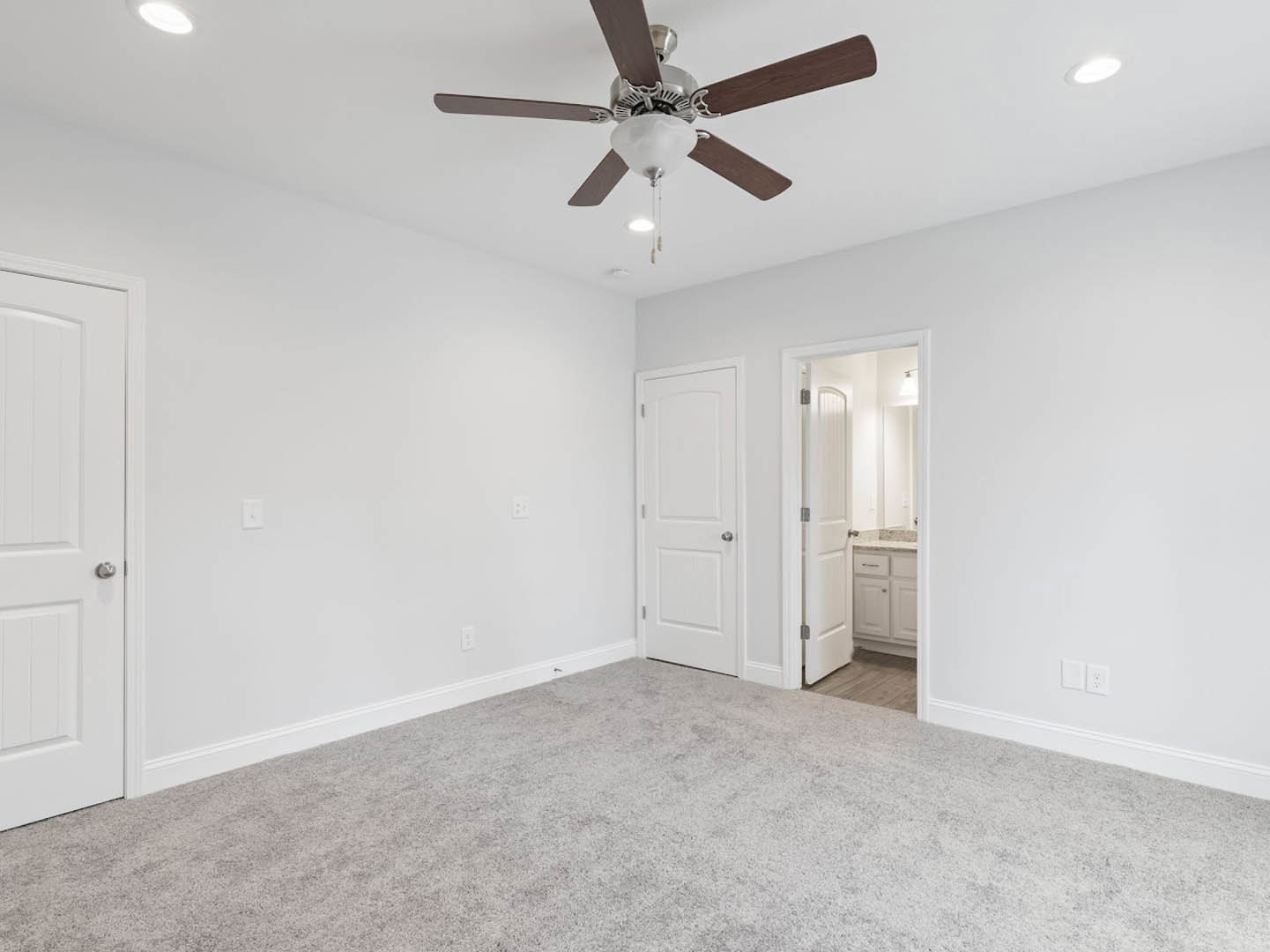 Carpeted room with a ceiling fan and light fixture, white door with silver knob, neutral walls, and plaster ceiling