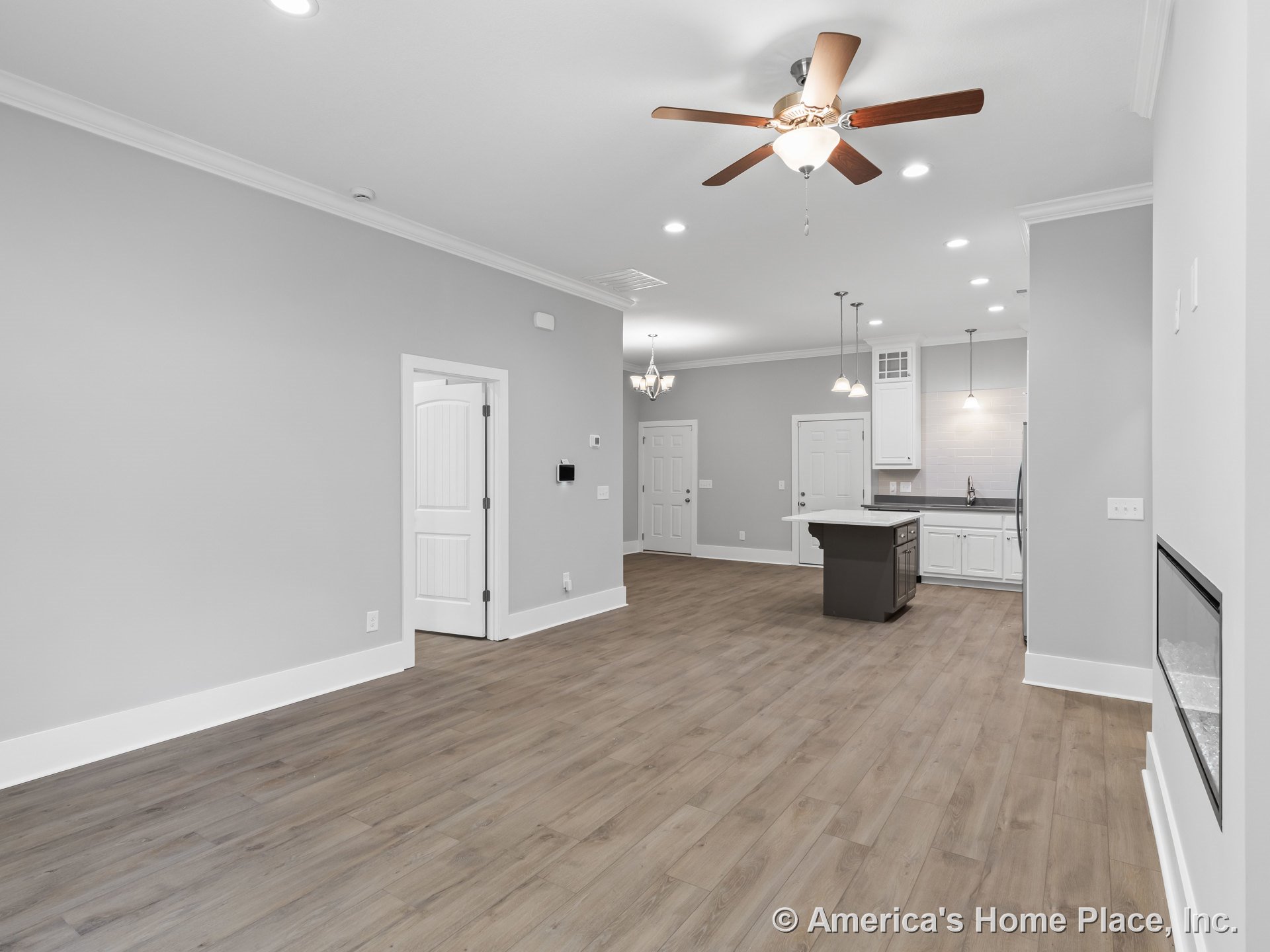 Open concept living area with wood-look plank flooring, recessed ceiling lights, ceiling fan, modern kitchen featuring white cabinetry, dark-base kitchen island, tile backsplash