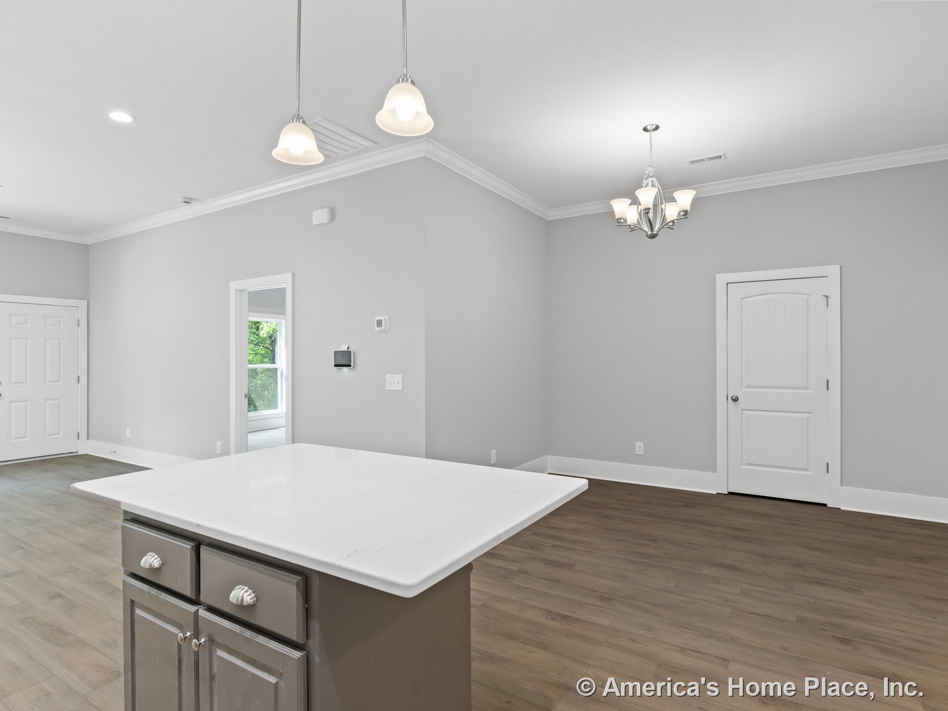 Open kitchen and living area with large white quartz island, gray cabinetry, wood-look plank flooring, recessed ceiling lights, modern chandelier, white paneled interior doors