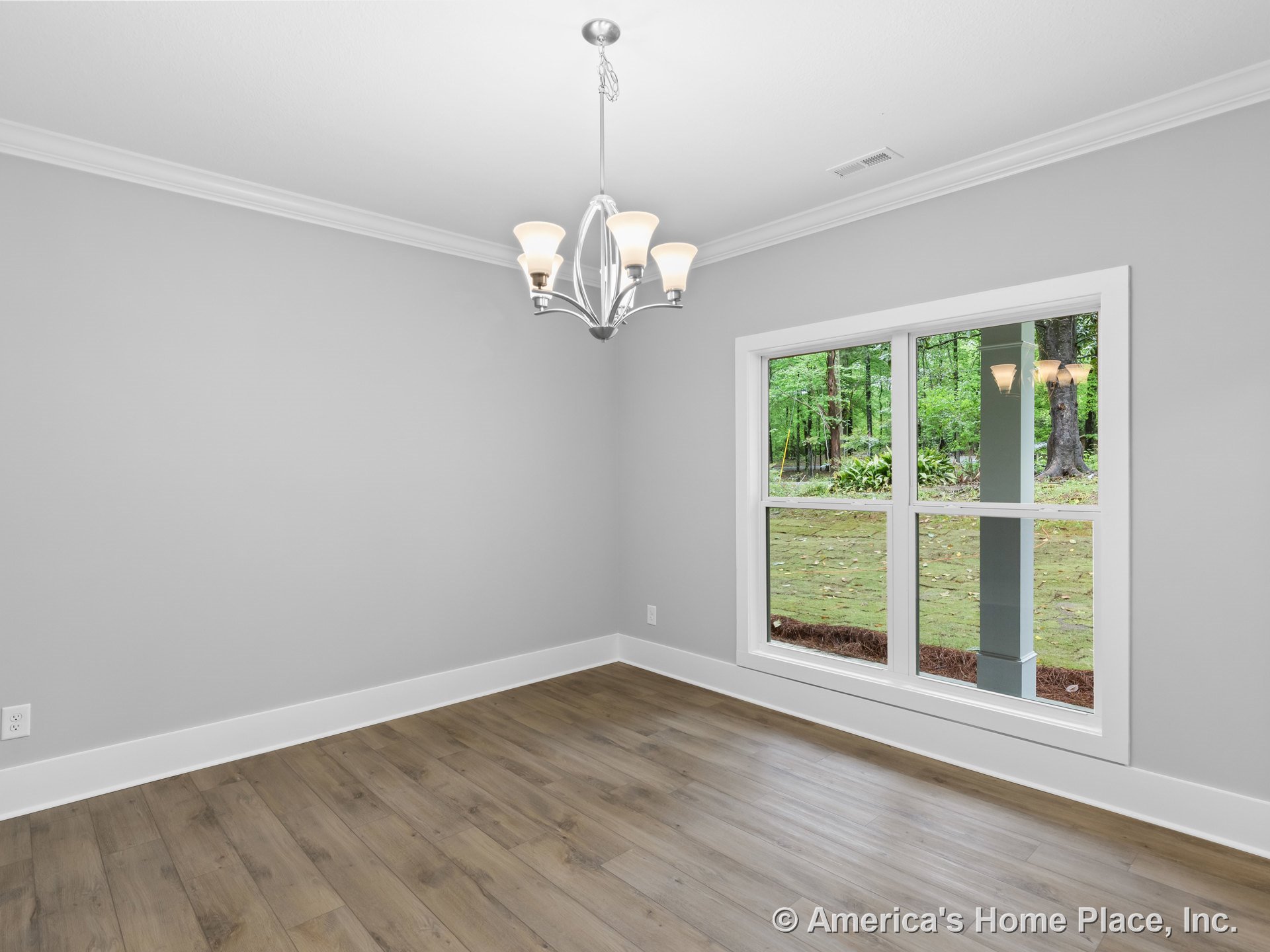 Dining room with large double windows, modern chandelier, gray painted walls, white crown molding and baseboards, wood-look plank flooring, and abundant natural light.