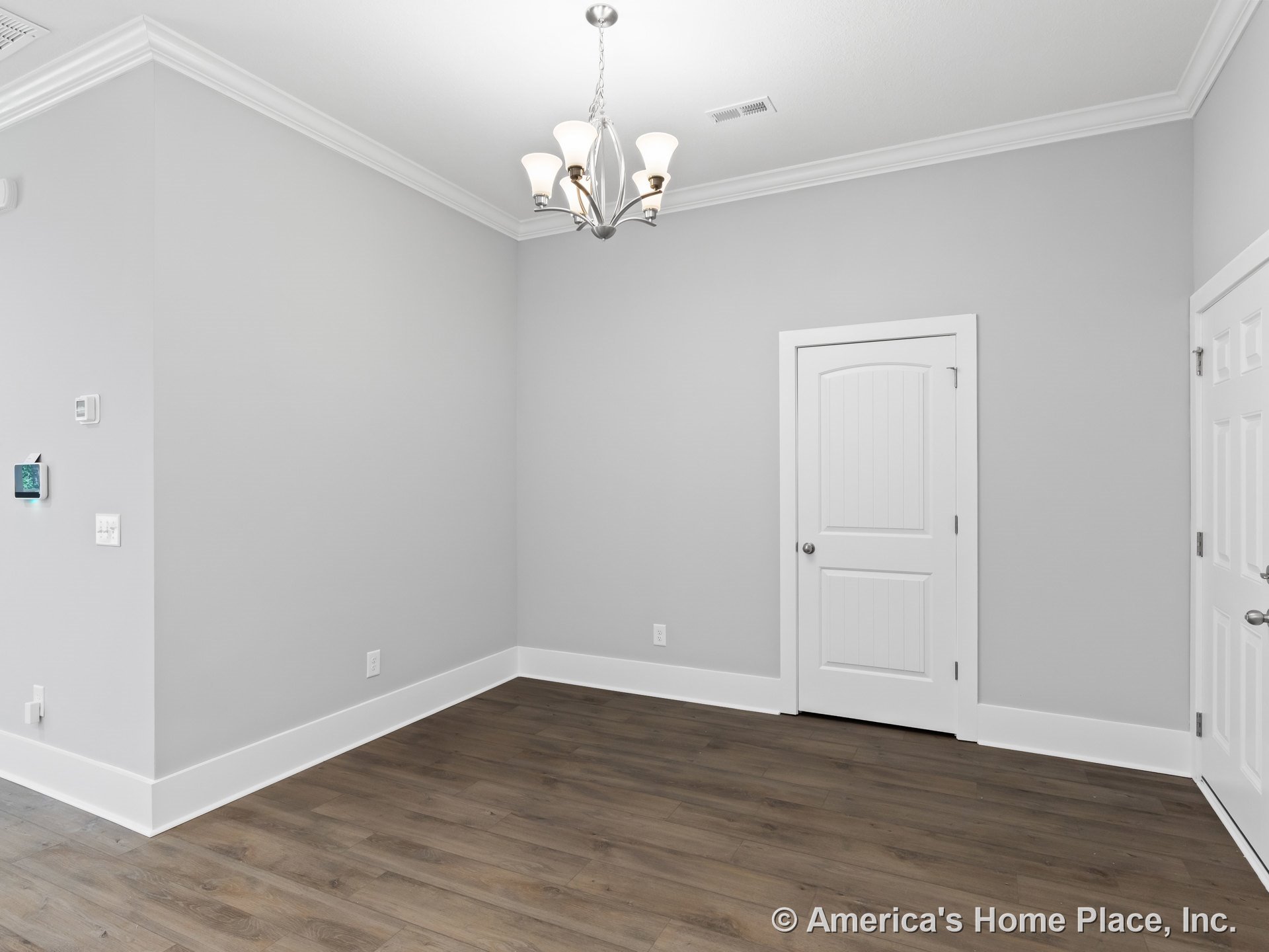 Light gray walls with white crown molding and wide baseboards, panel interior doors, modern chandelier, wood-look plank flooring, and wall-mounted thermostat.